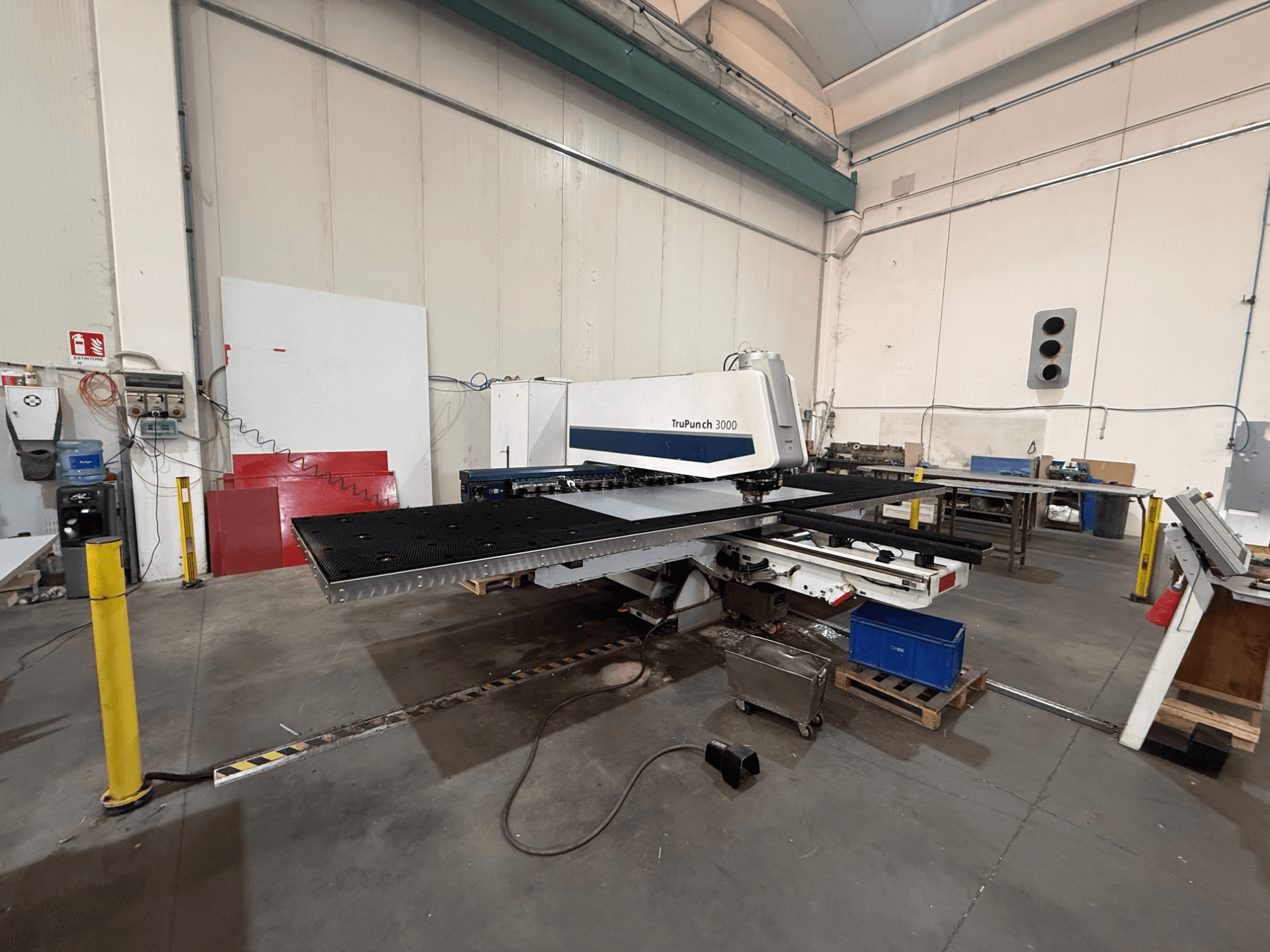 Punzonadora CNC TRUMPF TruPunch 3000, vista lateral, en la que se aprecian el cabezal de punzonado, la mesa de grandes dimensiones y el entorno del taller que la rodea.