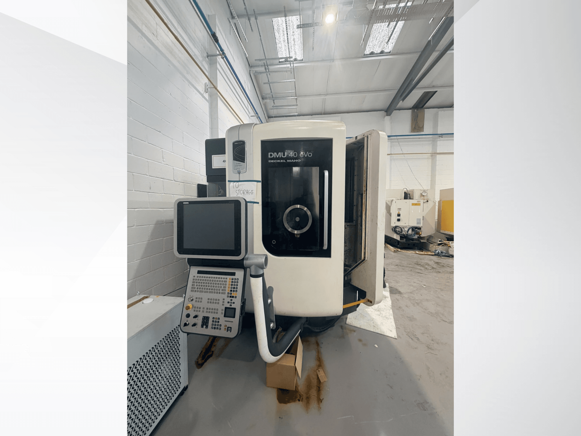 Vista frontal del centro de mecanizado vertical DMG DMU 40 evo, en la que se aprecian el panel de control y la zona del husillo, con el espacio de trabajo al fondo.