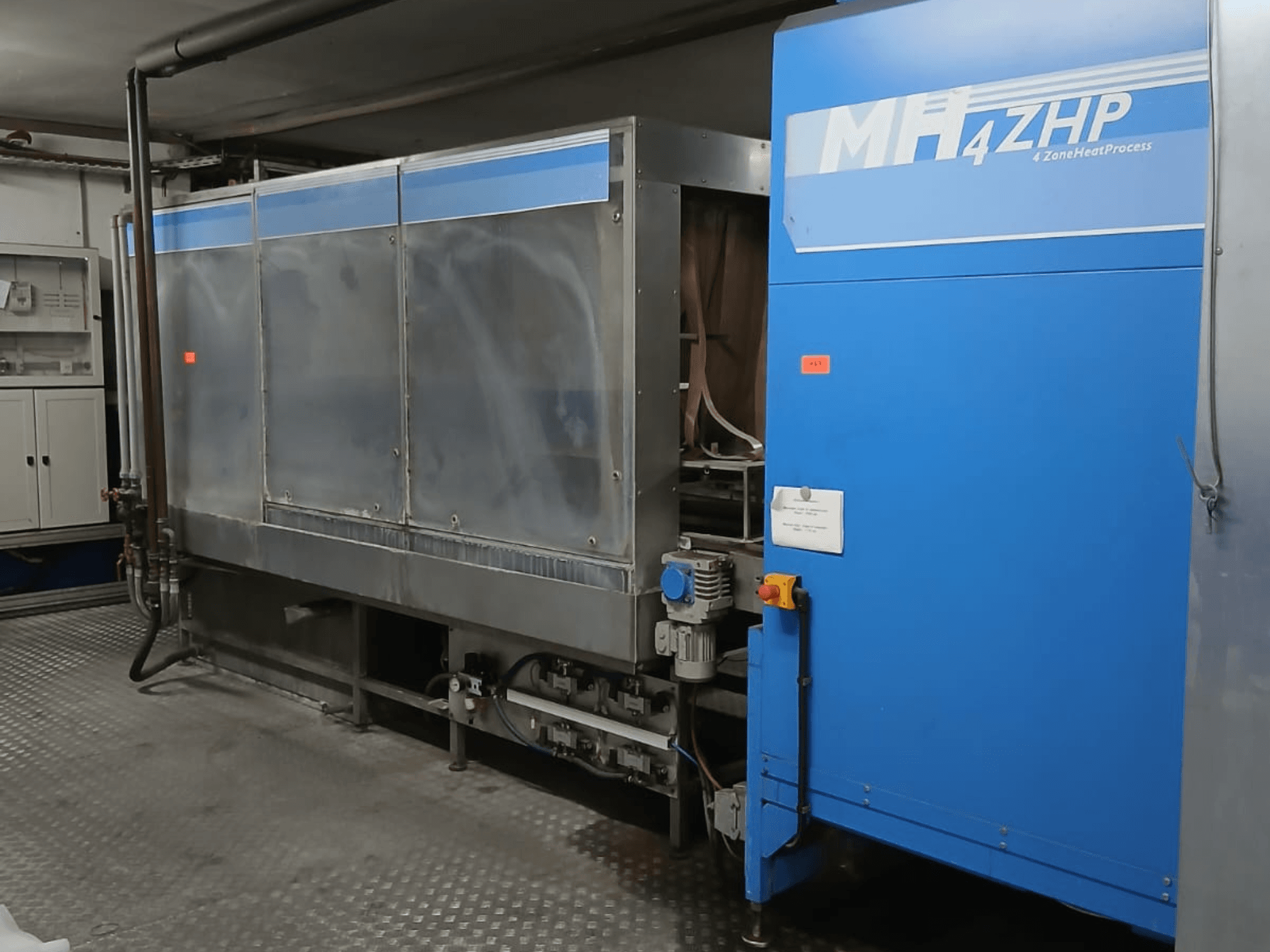 Máquina industrial MH 4ZHP en una vista lateral, mostrando la estructura de acero inoxidable y el panel azul con los elementos de control.