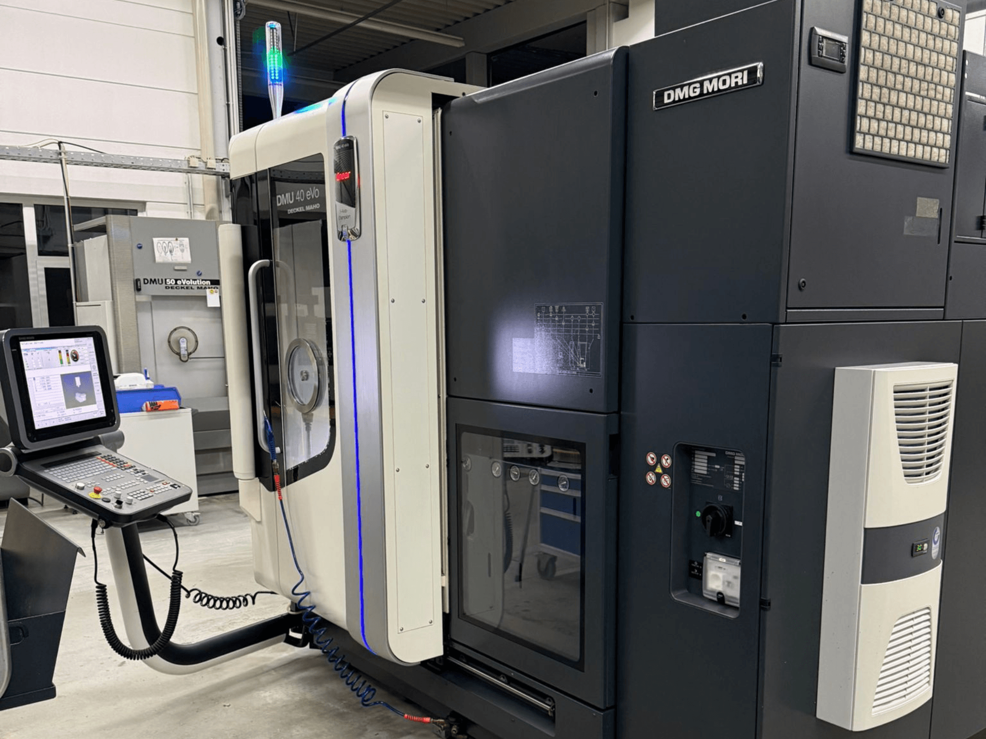 Máquina DMG MORI DMU 40 eVo, vista frontal que muestra los controles, los indicadores LED y el diseño elegante que enfatiza las características industriales.