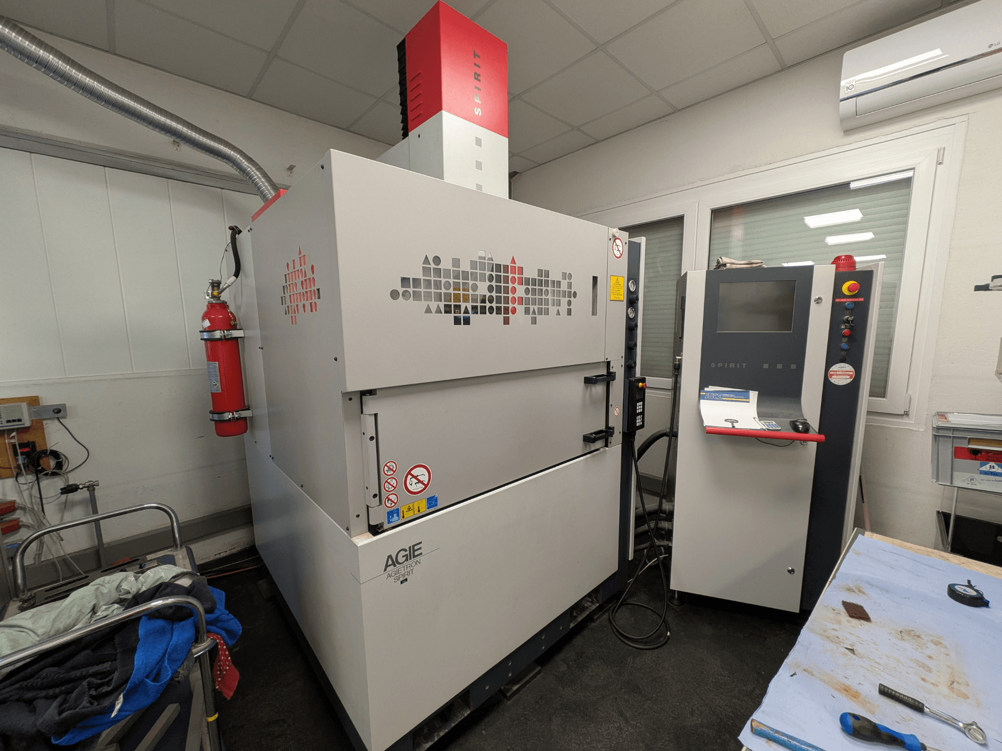Máquina de electroerosión por penetración AGIE AGIETRON SPIRIT 3, vista lateral, mostrando el panel de control y el extintor.
