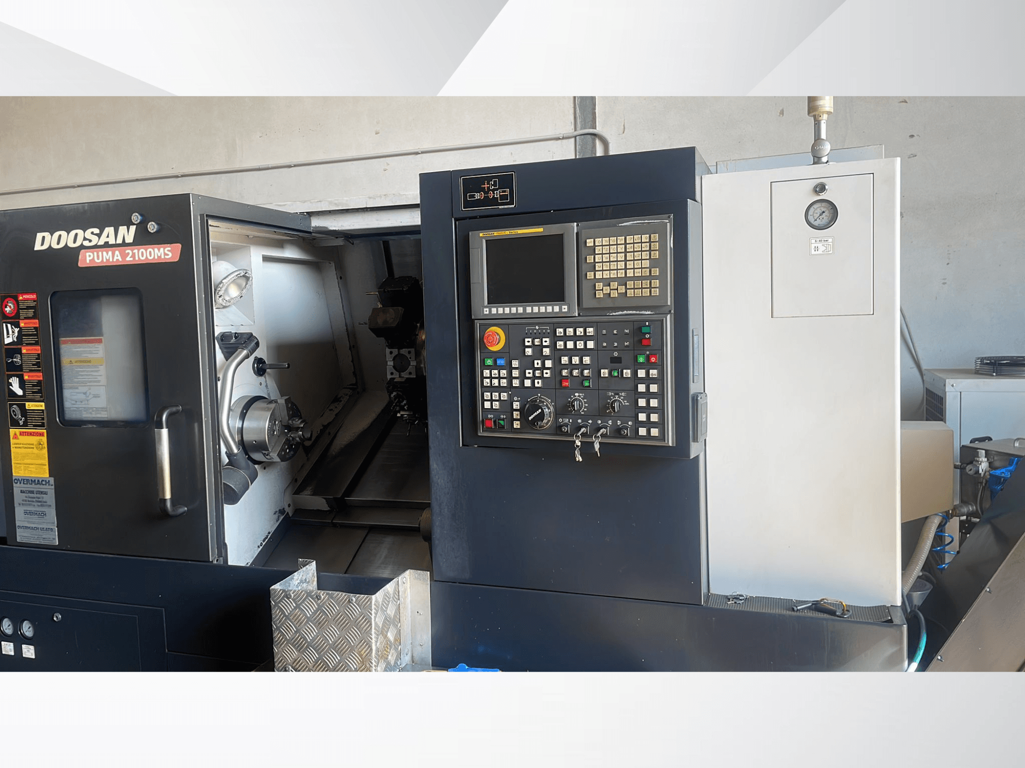 Vista frontal del torno horizontal DOOSAN PUMA 2100MS, en la que se aprecian el panel de control, el husillo y las herramientas de corte dentro de la cámara.
