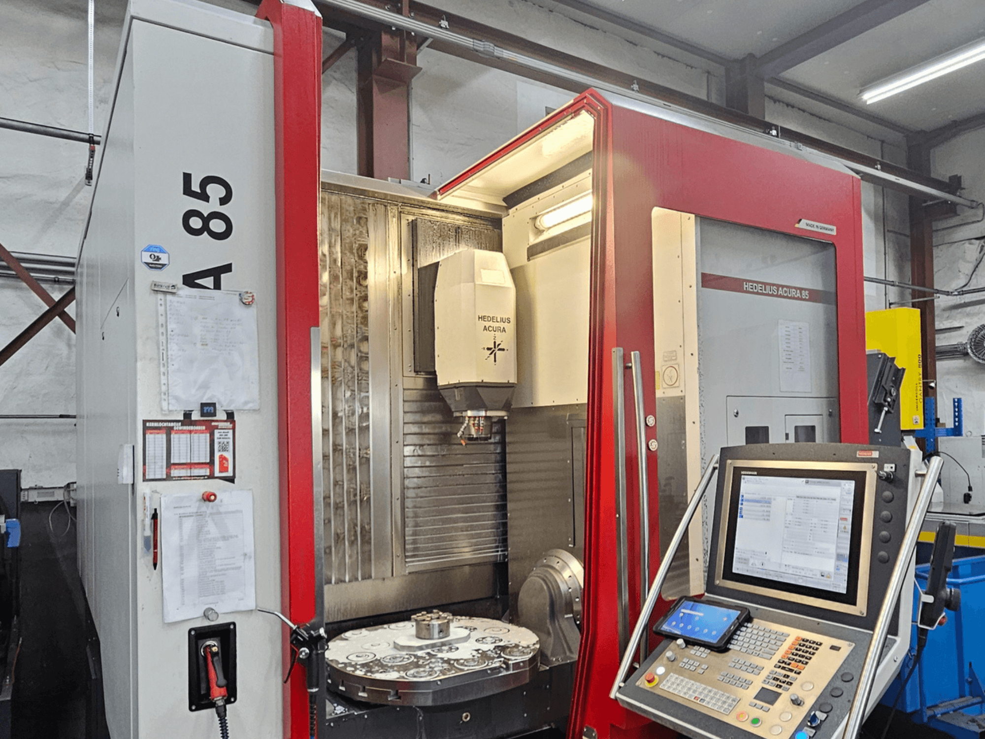 Centro de mecanizado vertical HEDLIUS Acura 85, vista frontal, con panel de control y mesa giratoria para mecanizado de precisión.