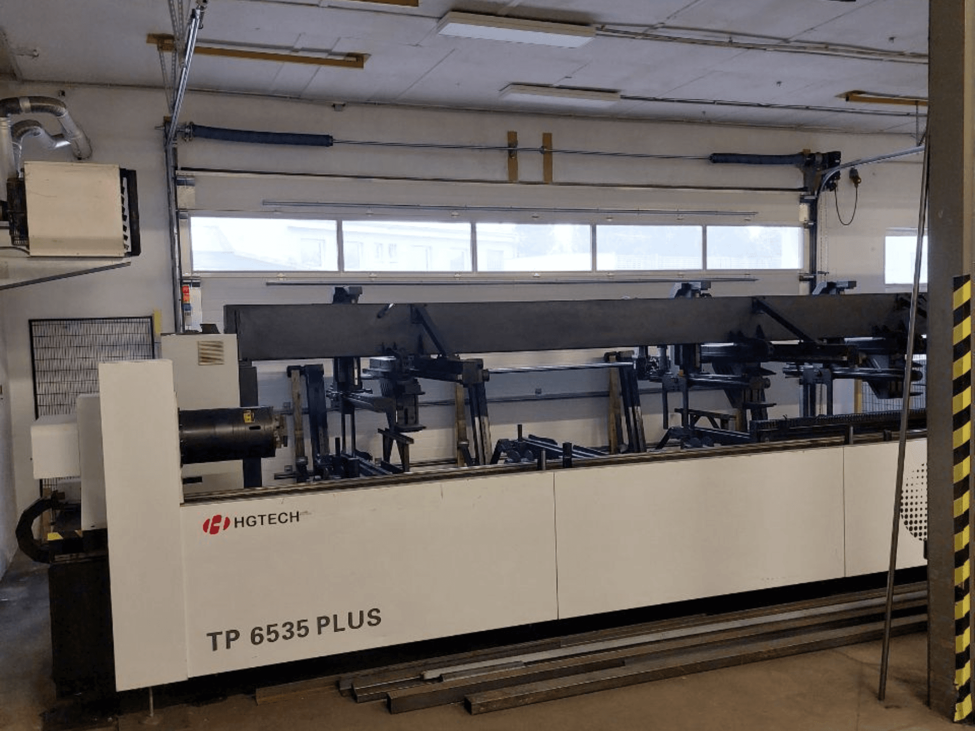 HGTECH TP 6535 PLUS, vista frontal de una gran máquina industrial con múltiples brazos para fabricación de precisión, situada en un taller.