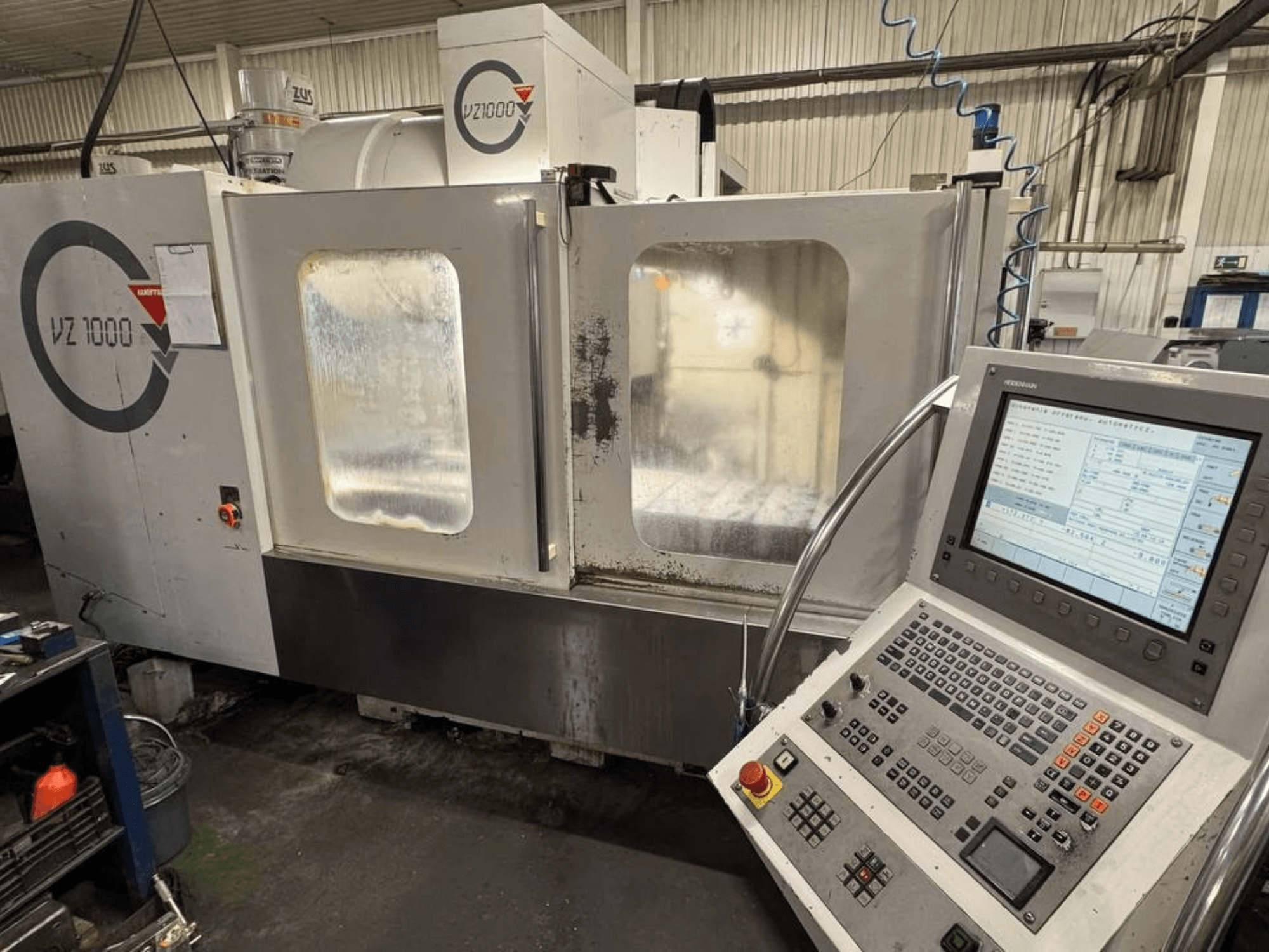 Vista frontal del centro de mecanizado vertical WEMAS VZ 1000, con panel de control y puertas de acceso transparentes.