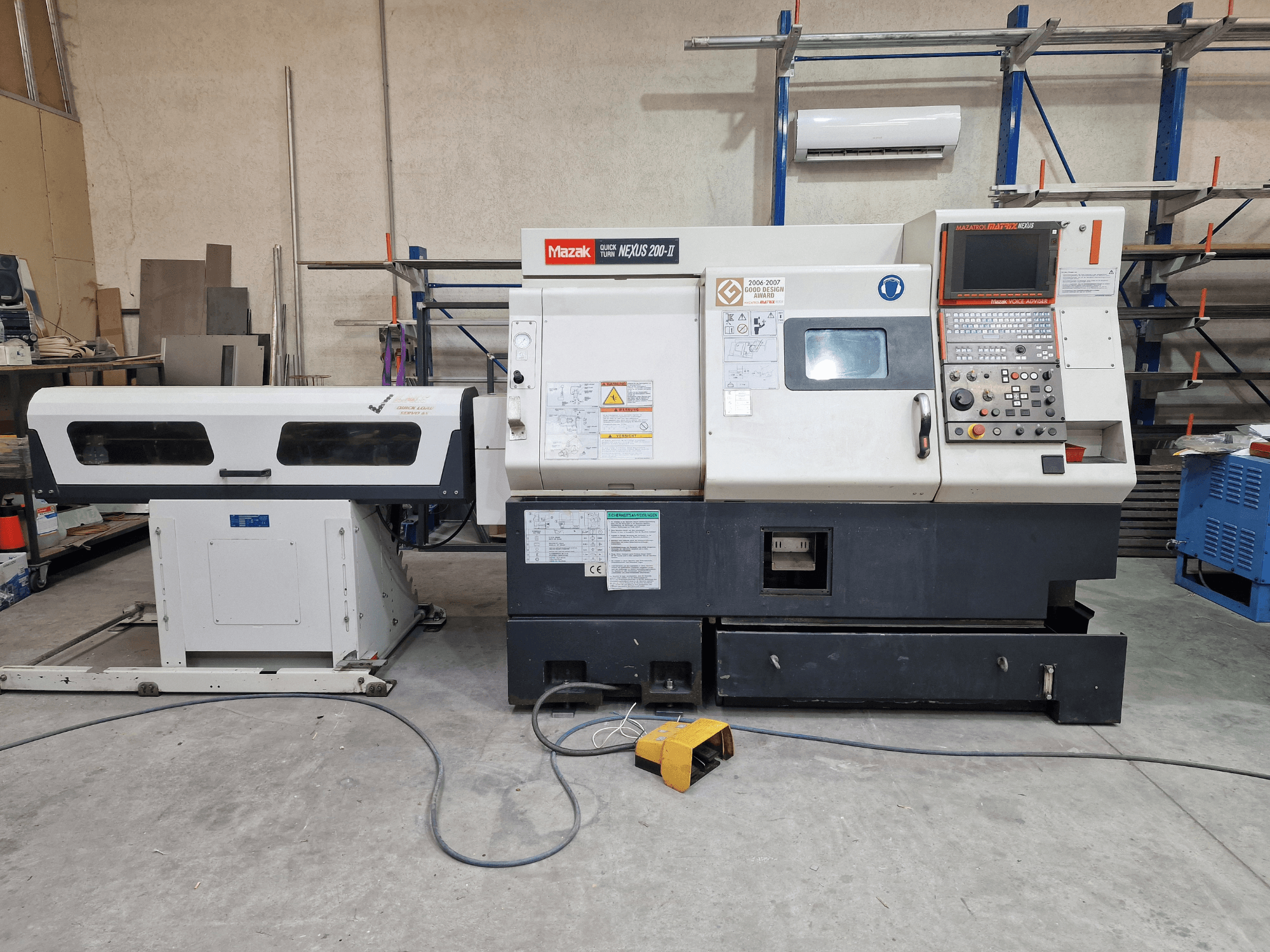 Torno horizontal Mazak QuickTurn Nexus 200, vista lateral, en la que se aprecian el panel de control, el husillo y la bandeja recogevirutas.
