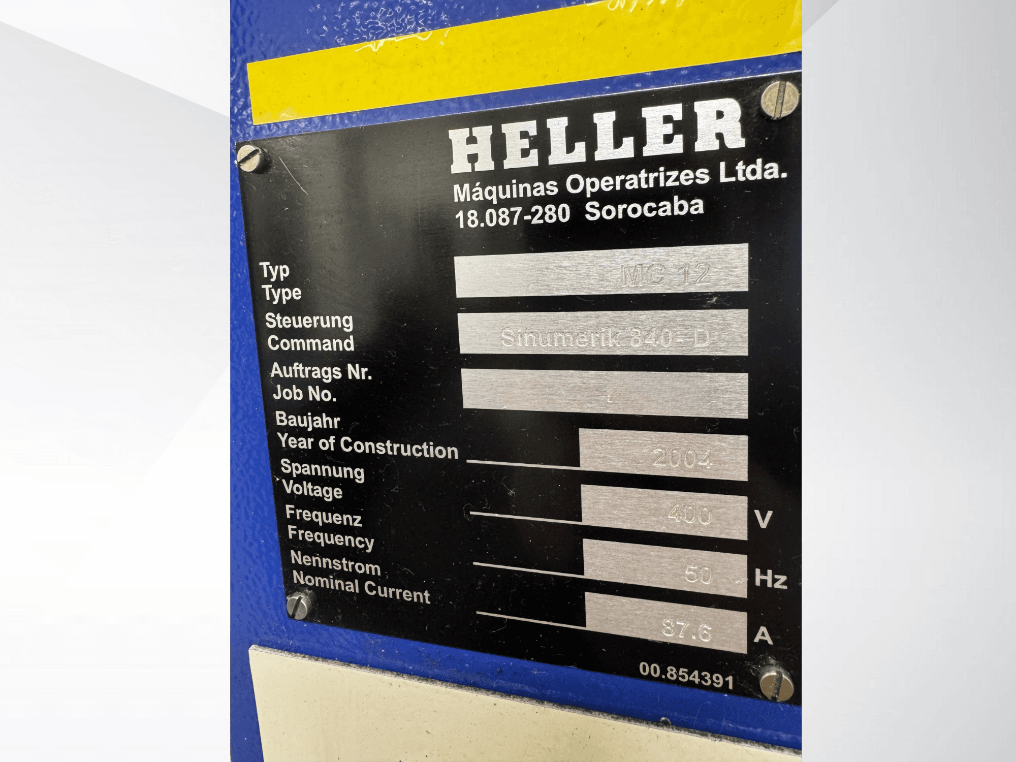 Placa de identificación de metal negro para Heller MC 12 con Sinumerik 840-D, que muestra la tensión de 400 V, la frecuencia de 50 Hz y el año 2004.