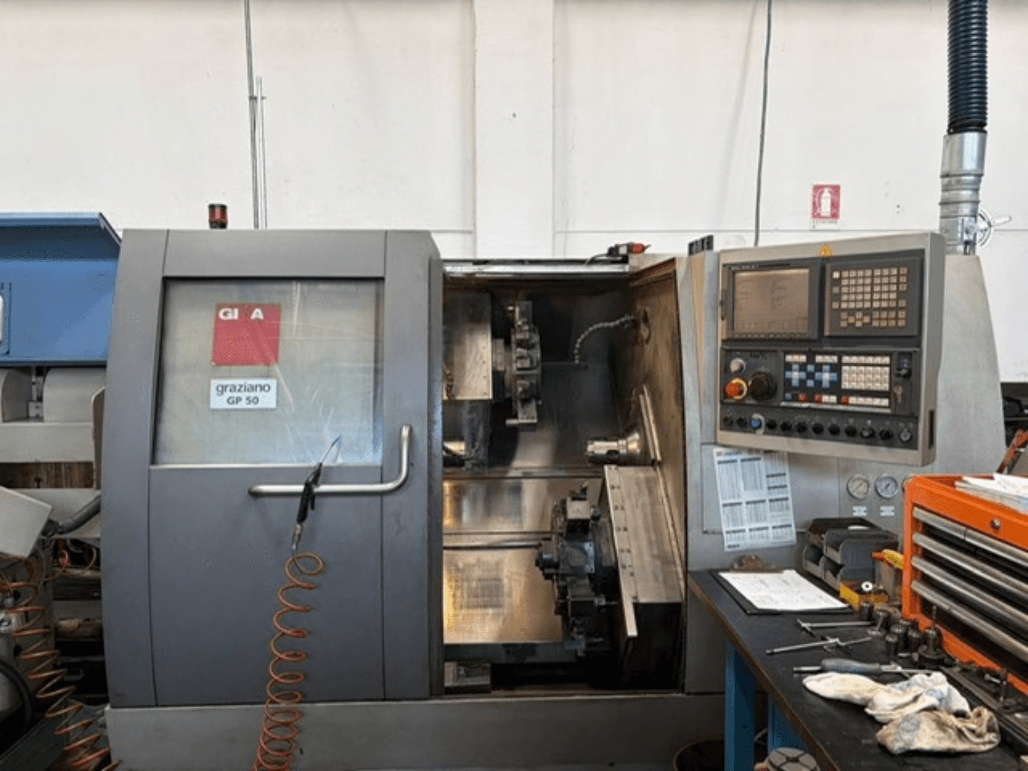 Torno horizontal Gildemeister GP 50, vista frontal, en la que se aprecian el panel de control y el espacio de trabajo abierto con las herramientas.