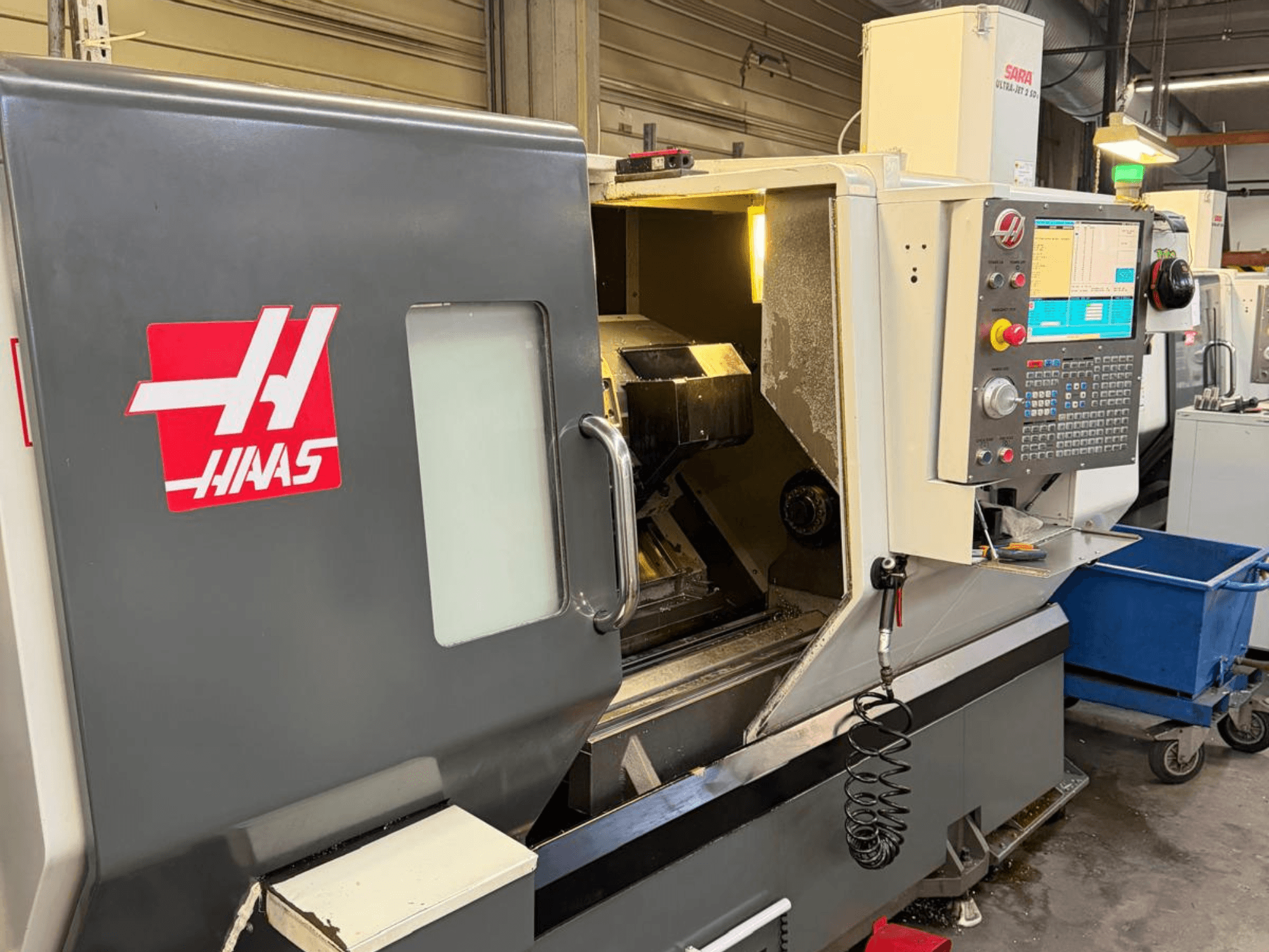 Tornero horizontal HAAS DS-30SSY, vista frontal, con panel de control y componentes internos visibles, en entorno de taller.