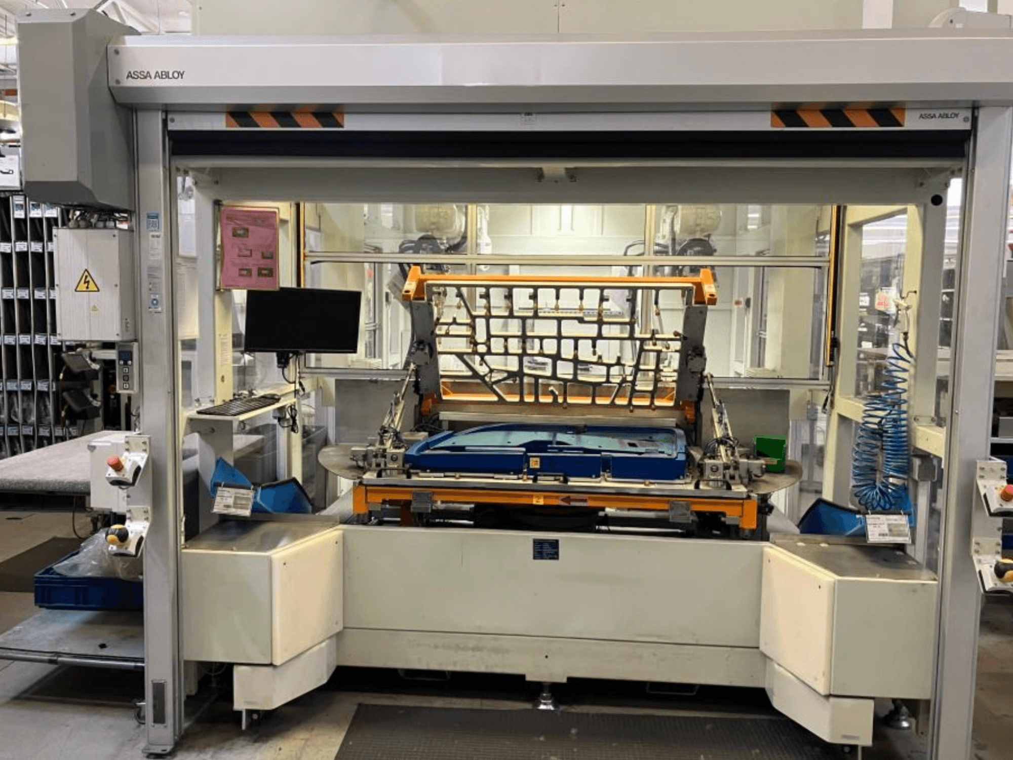 Máquina con brazo robótico CHANGO AUDI TSV D5 TÜR en una fábrica; vista frontal en la que se aprecian el panel de control y el área de trabajo.