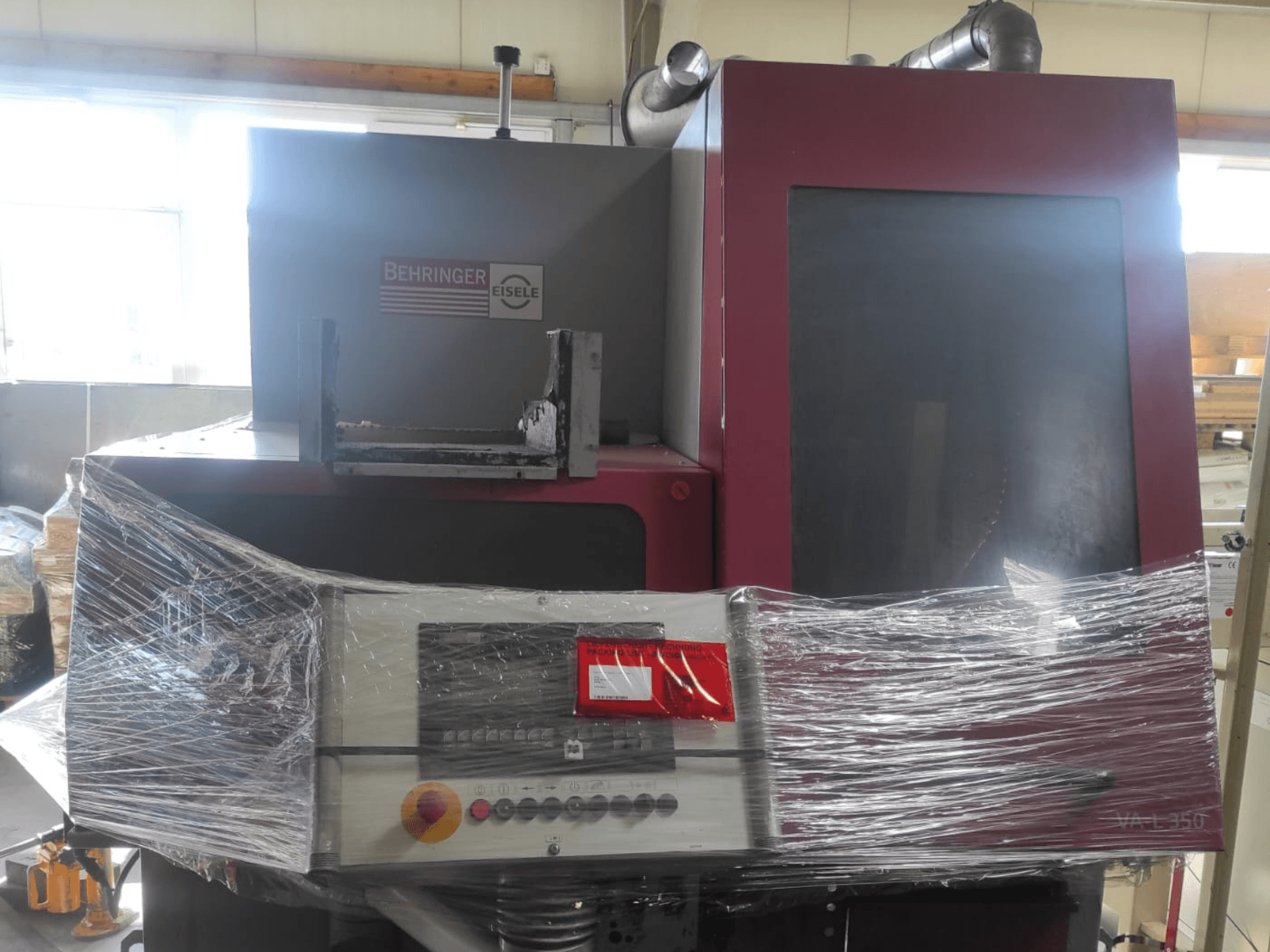 Máquina Behringer Eisele VA L 560, vista frontal, envuelta en plástico, con panel de control y botones visibles.