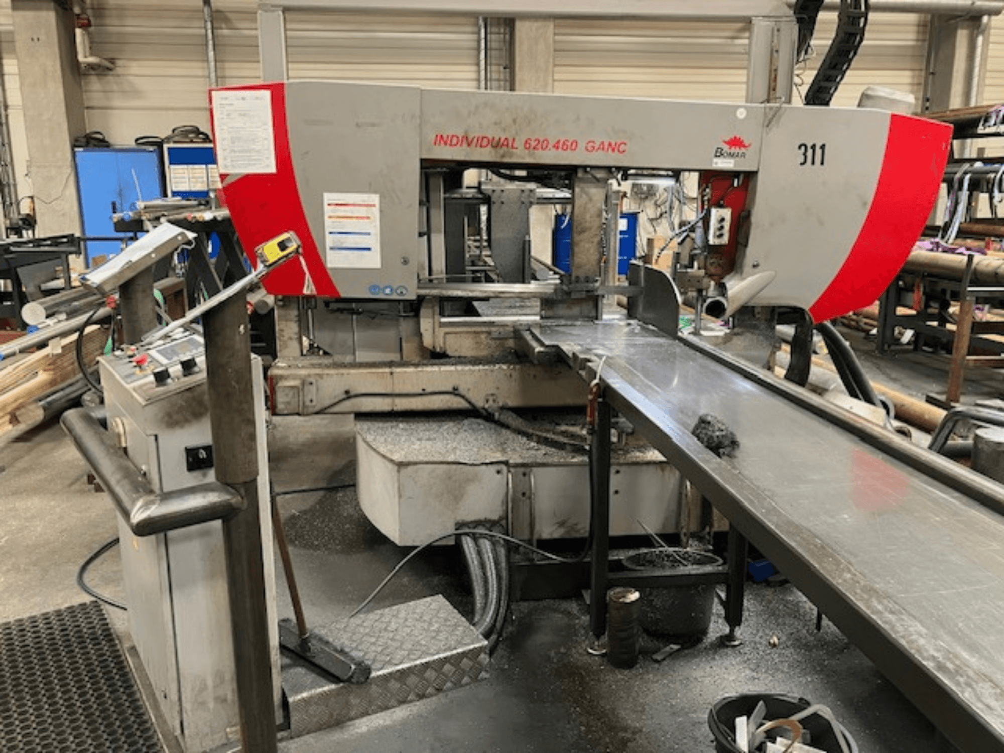 Sierra de cinta BOMAR INDIVIDUAL 620-460 GANC, vista frontal, mostrando controles, área de corte y fondo de taller industrial.