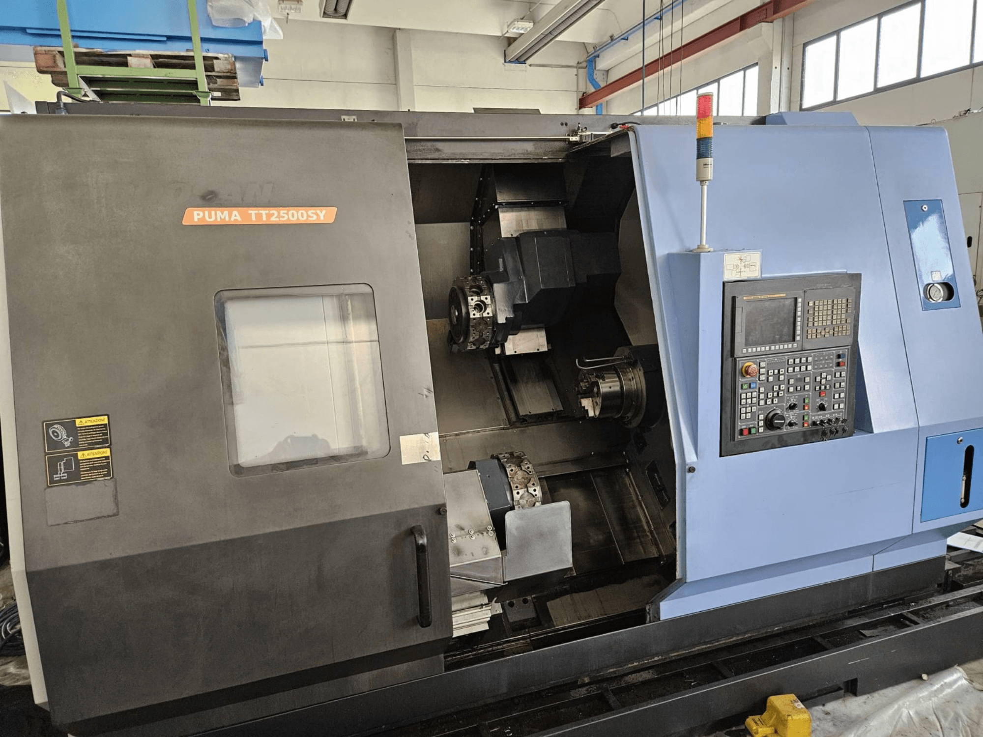 Torno multihusillo DOOSAN PUMA TT2500SY, vista frontal en la que se aprecian el panel de control y los detalles del interior de la máquina.