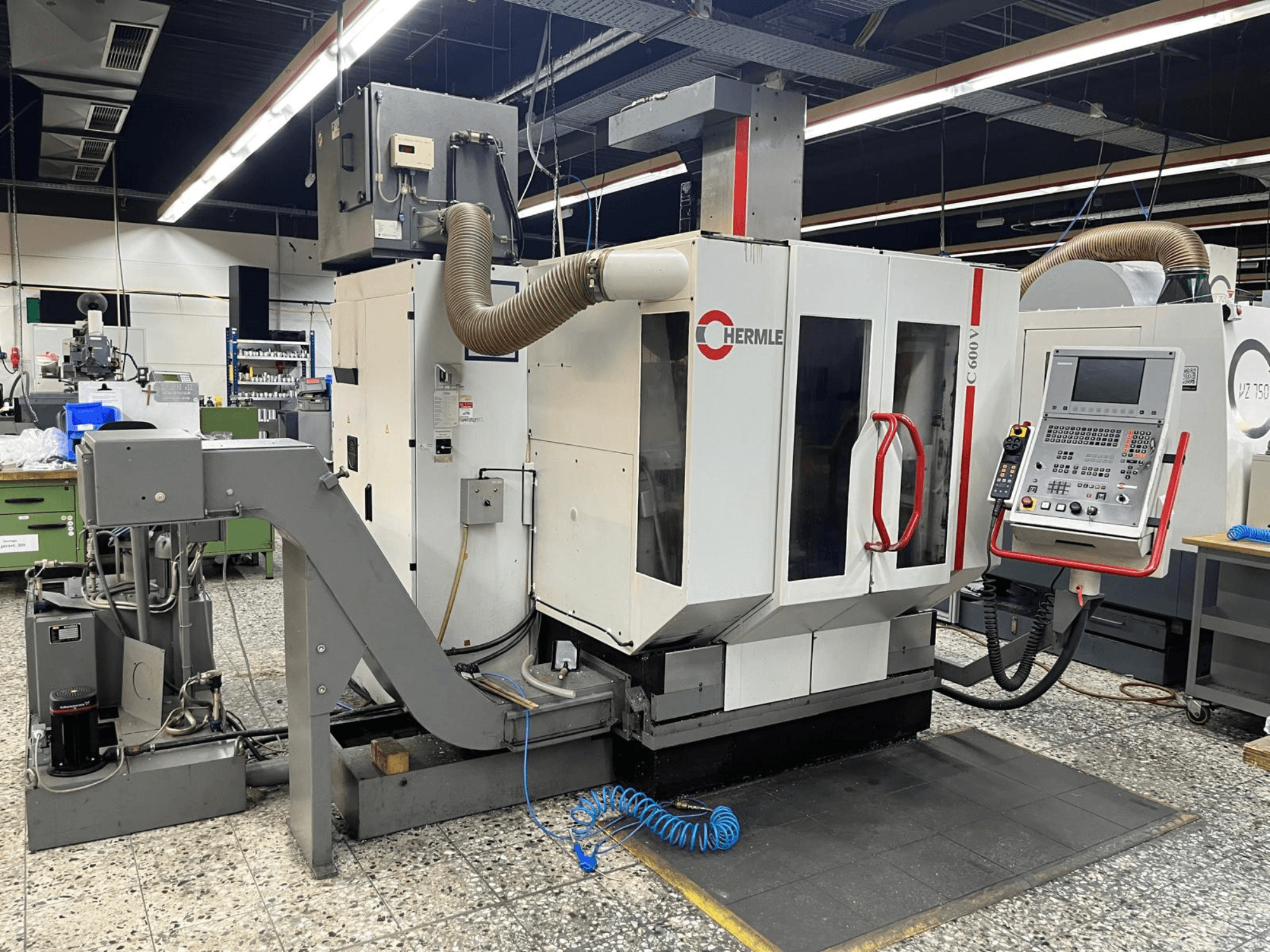 Centro de mecanizado vertical HERMLE C 600 V en un taller, vista frontal que muestra el panel de control y las características de ventilación.