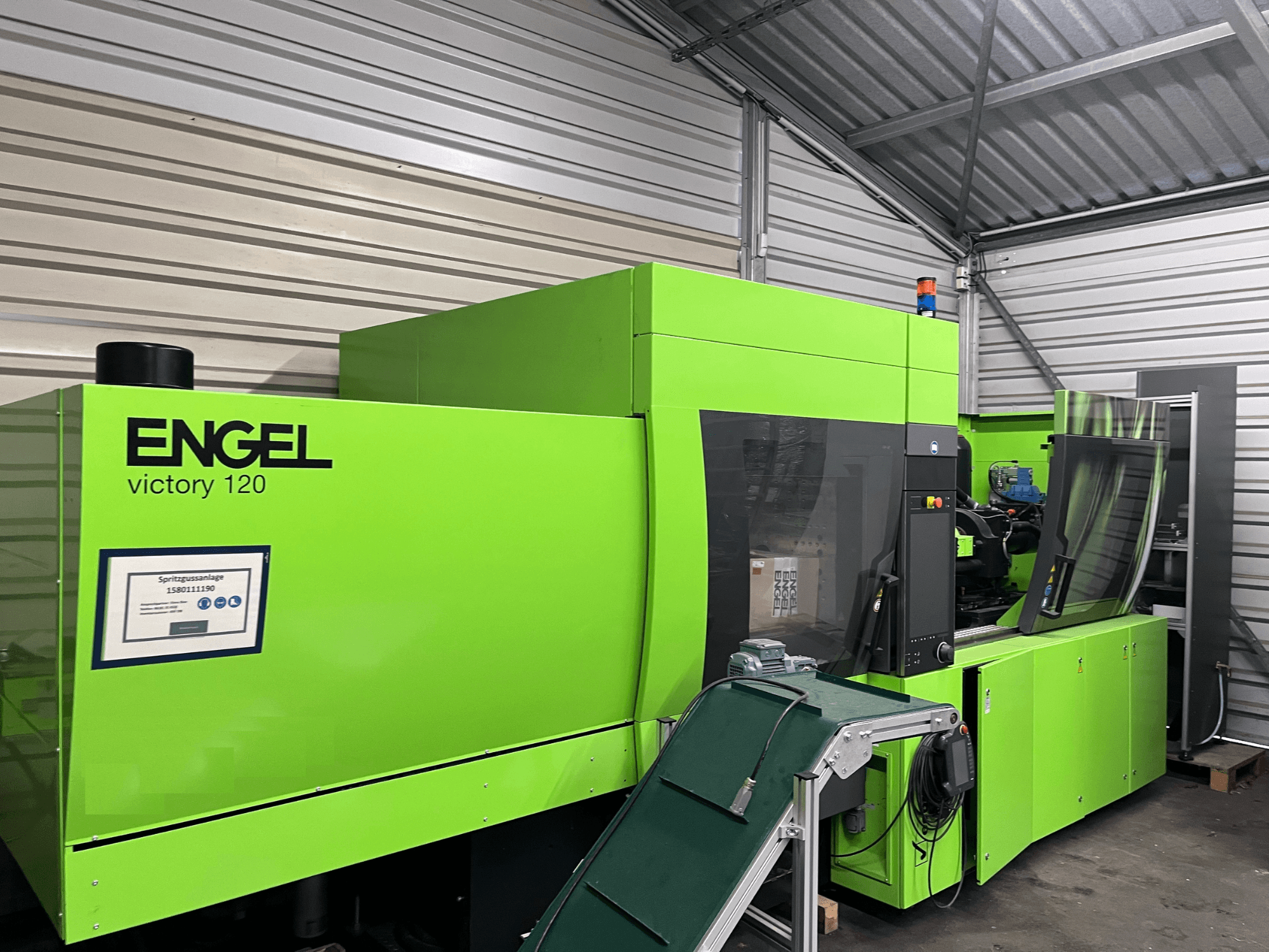 Máquina de moldeo por inyección hidráulica Engel Victory 120 BMG verde, vista frontal que muestra el panel de control y los componentes de la máquina.