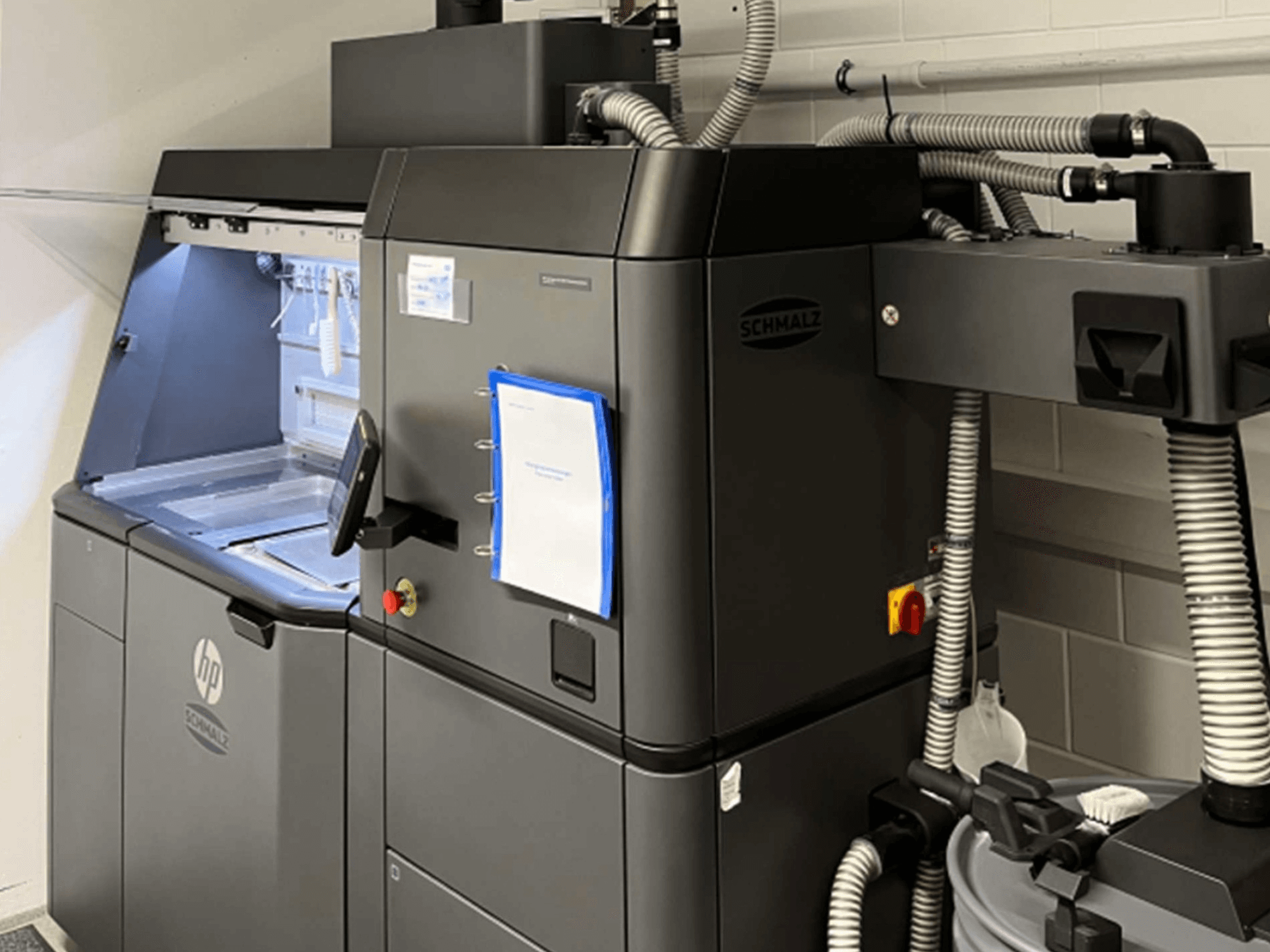 Impresora 3D de plástico HP Jet Fusion 3D 4200, vista lateral, en la que se aprecian el panel de control y los componentes internos.