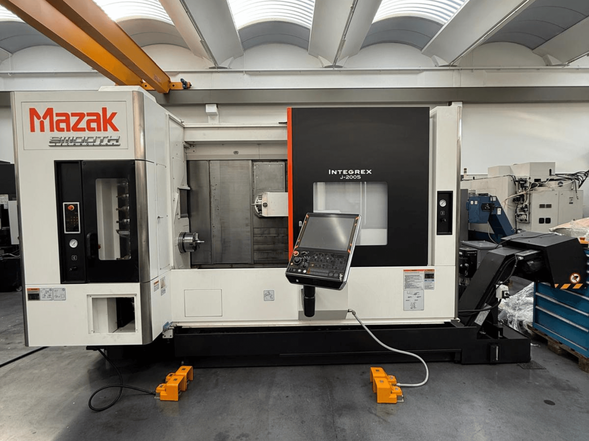Centro de fresado y torneado Mazak INTEGREX J-200 S en vista frontal, con panel de control y área de mecanizado, colocado en el suelo de la fábrica.