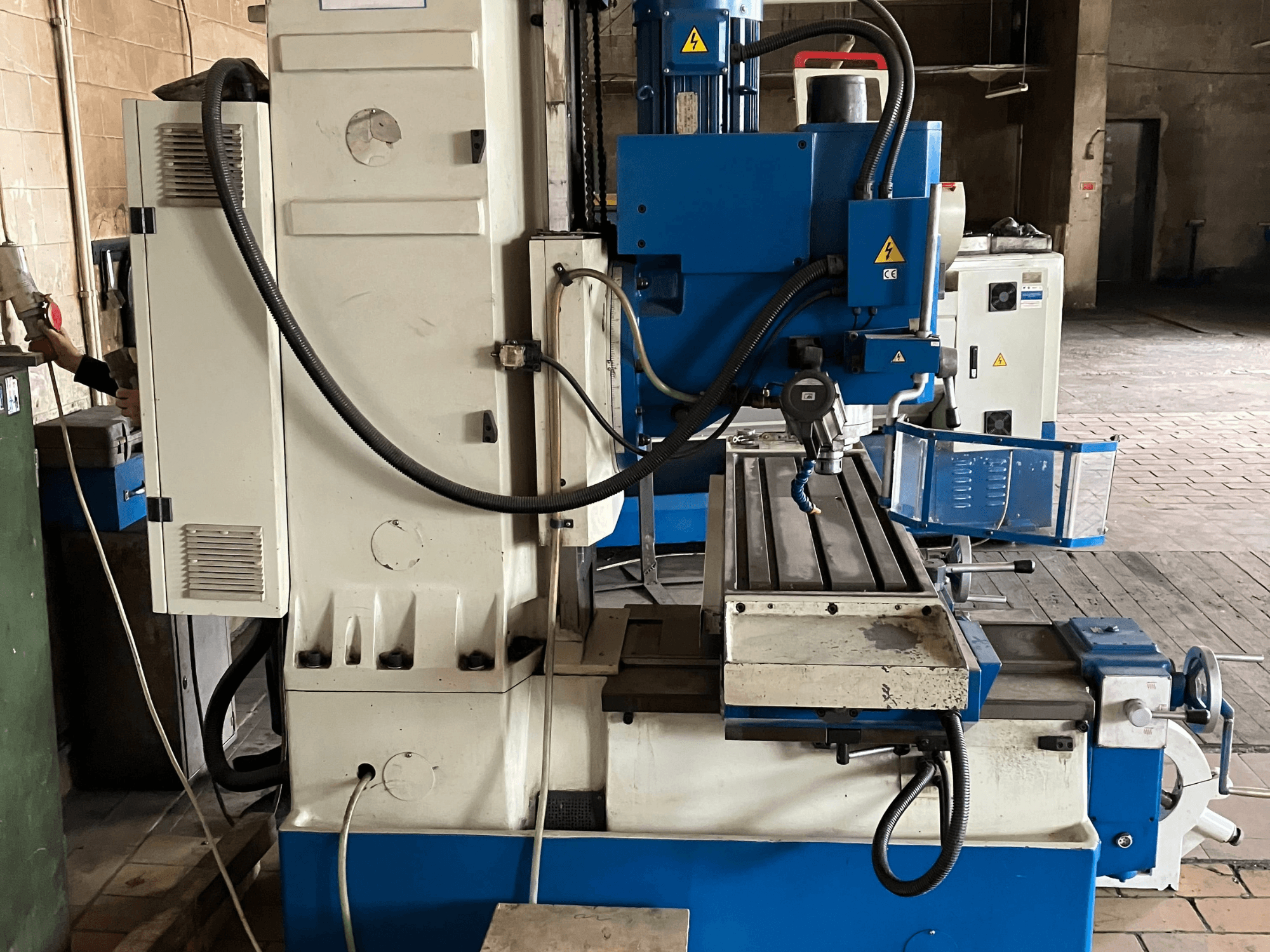 Centro de mecanizado vertical KNUTH KB 1400, vista frontal en la que se aprecian el panel de control, la herramienta de corte y la mesa de trabajo con guías lineales.