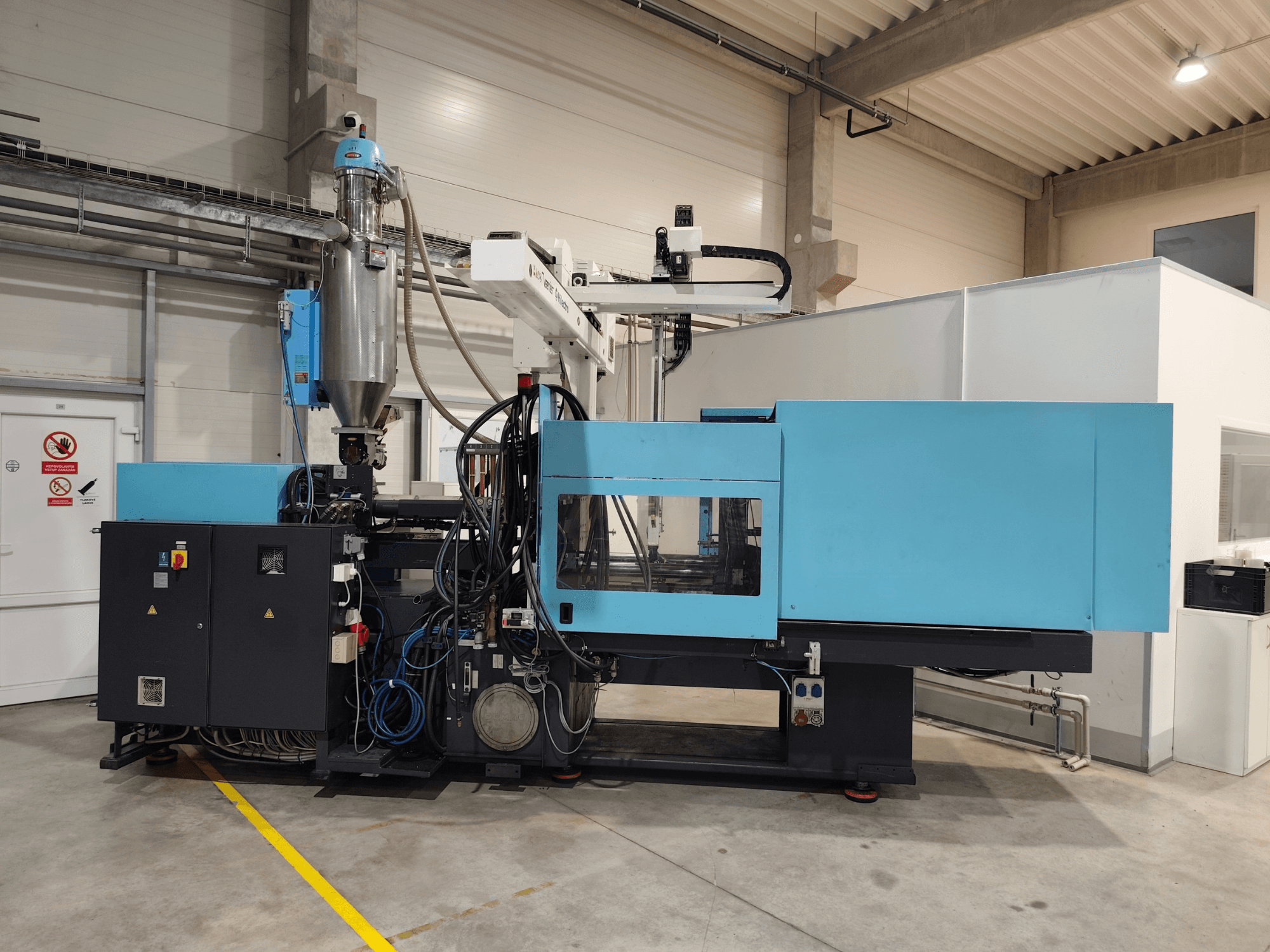 Vista frontal de una máquina de moldeo por inyección hidráulica DEMAG Ergotech Extra 160-430, en la que se aprecian el panel de control y la tolva.