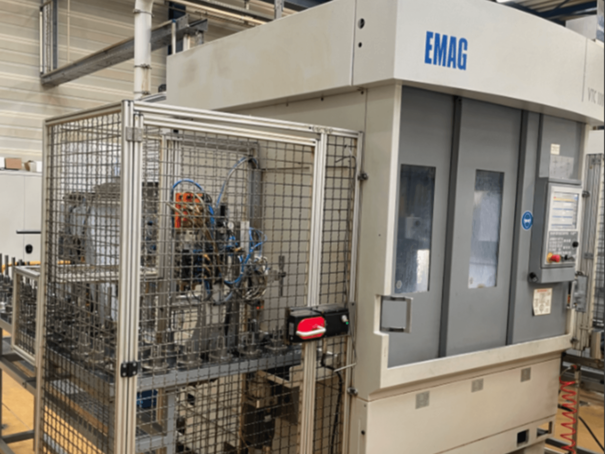 Torno vertical EMAG VTC 100 en vista lateral, en la que se aprecian los detalles del panel de control y las vallas de seguridad.