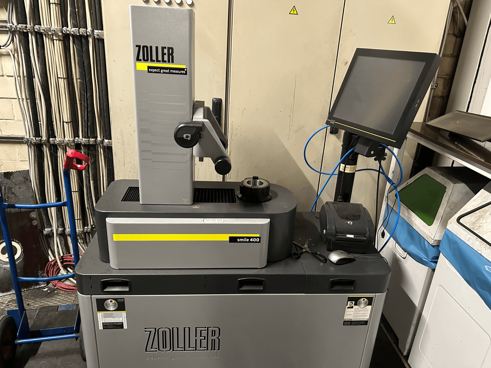 Máquina de medición ZOLLER smile 400 en gris, vista frontal, con pantalla táctil, portaherramientas e impresora sobre una superficie de trabajo.