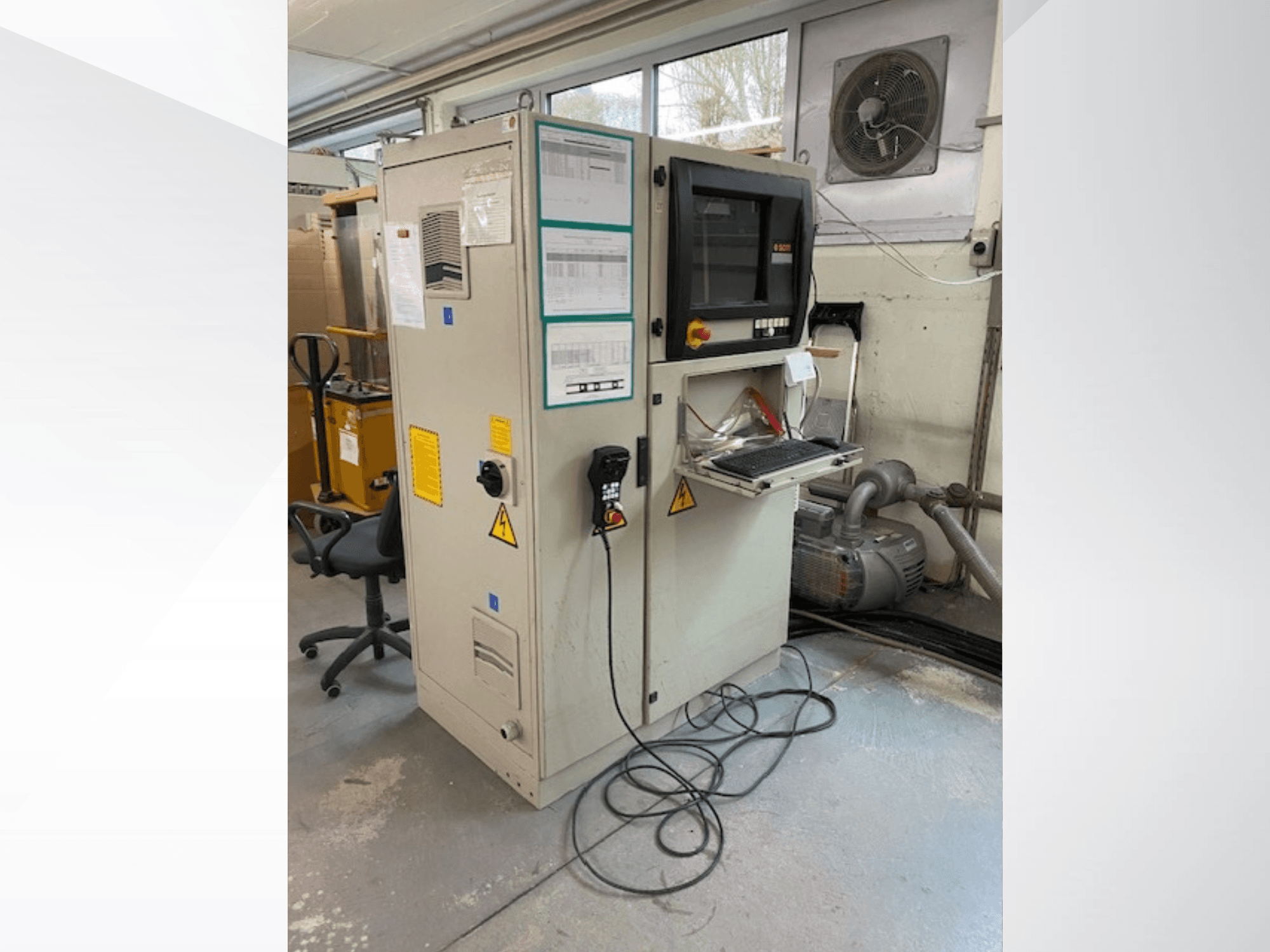 Centro de mecanizado de madera SCM Record 240 CNC en vista lateral, con panel de control, etiquetas de seguridad y conectado a un motor.