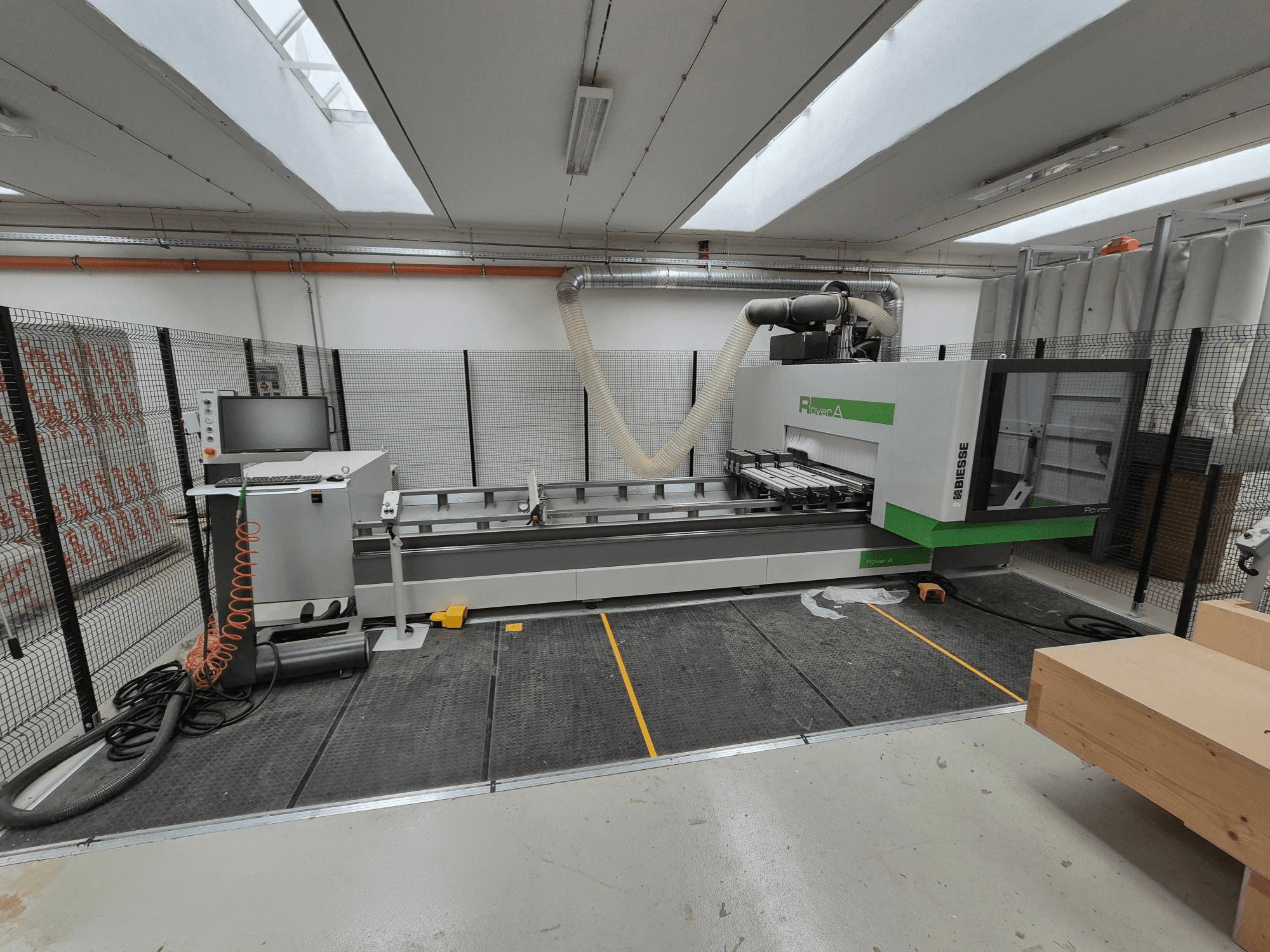 Biesse Rover Una máquina CNC en un taller, vista frontal. Incluye un panel de control, un sistema de vacío y una superficie de trabajo.