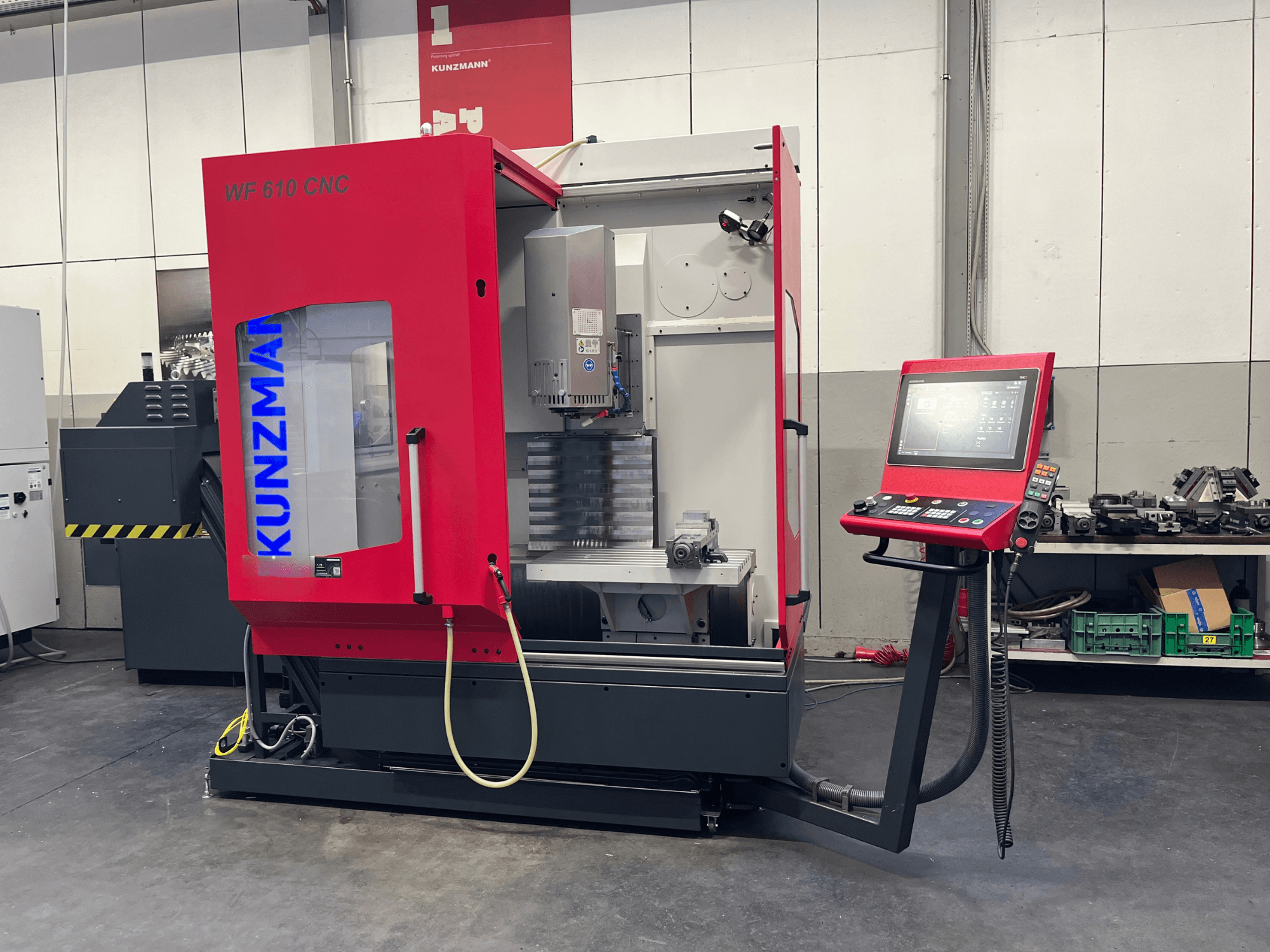 Centro de mecanizado vertical CNC KUNZMANN WF 610 en un taller, en el que se aprecian el panel de control y los componentes de la máquina.