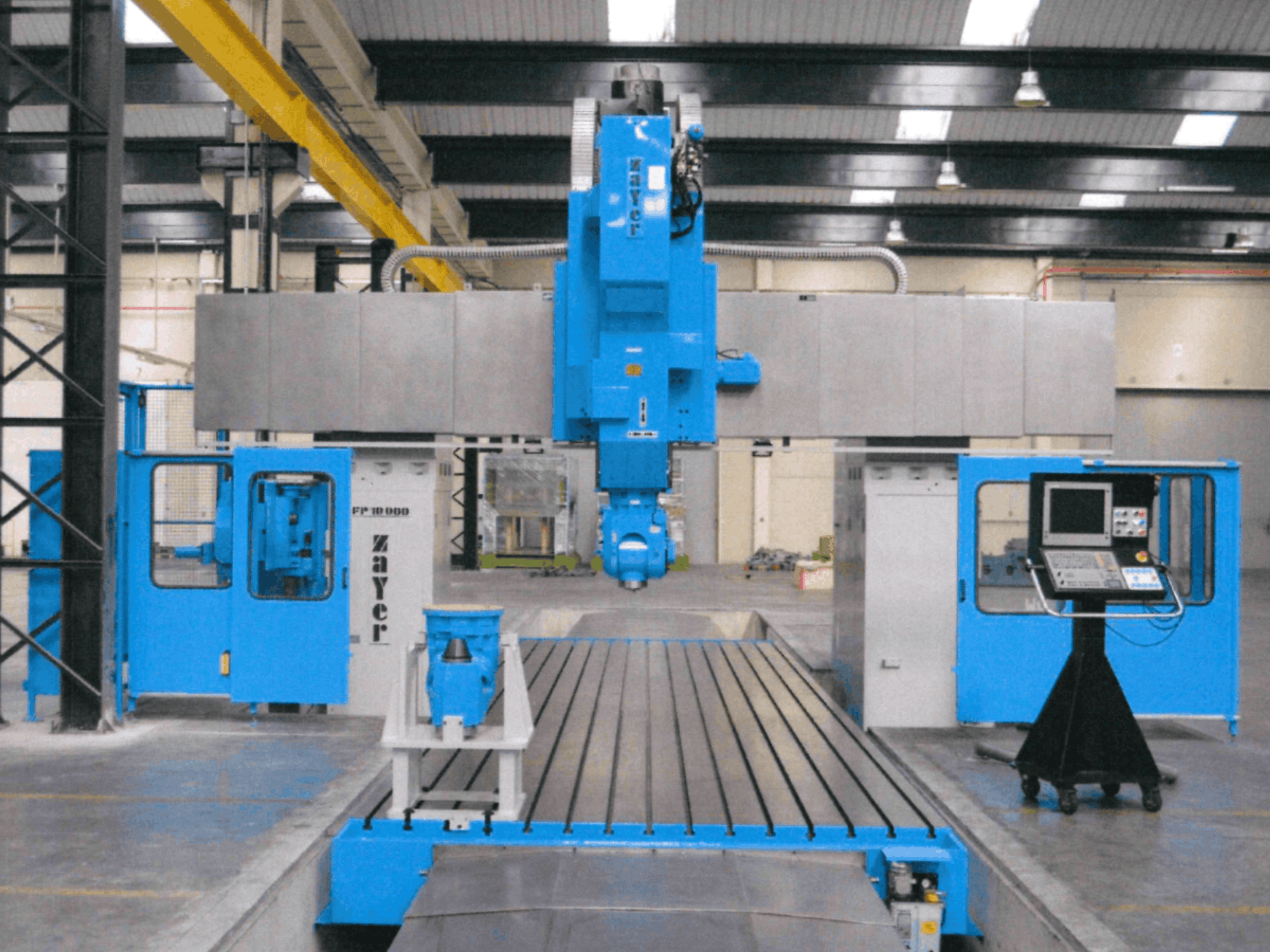 Vista frontal de la fresadora de bancada Zayer FP-10000, en la que se aprecian su estructura azul, el panel de control y los componentes de precisión.