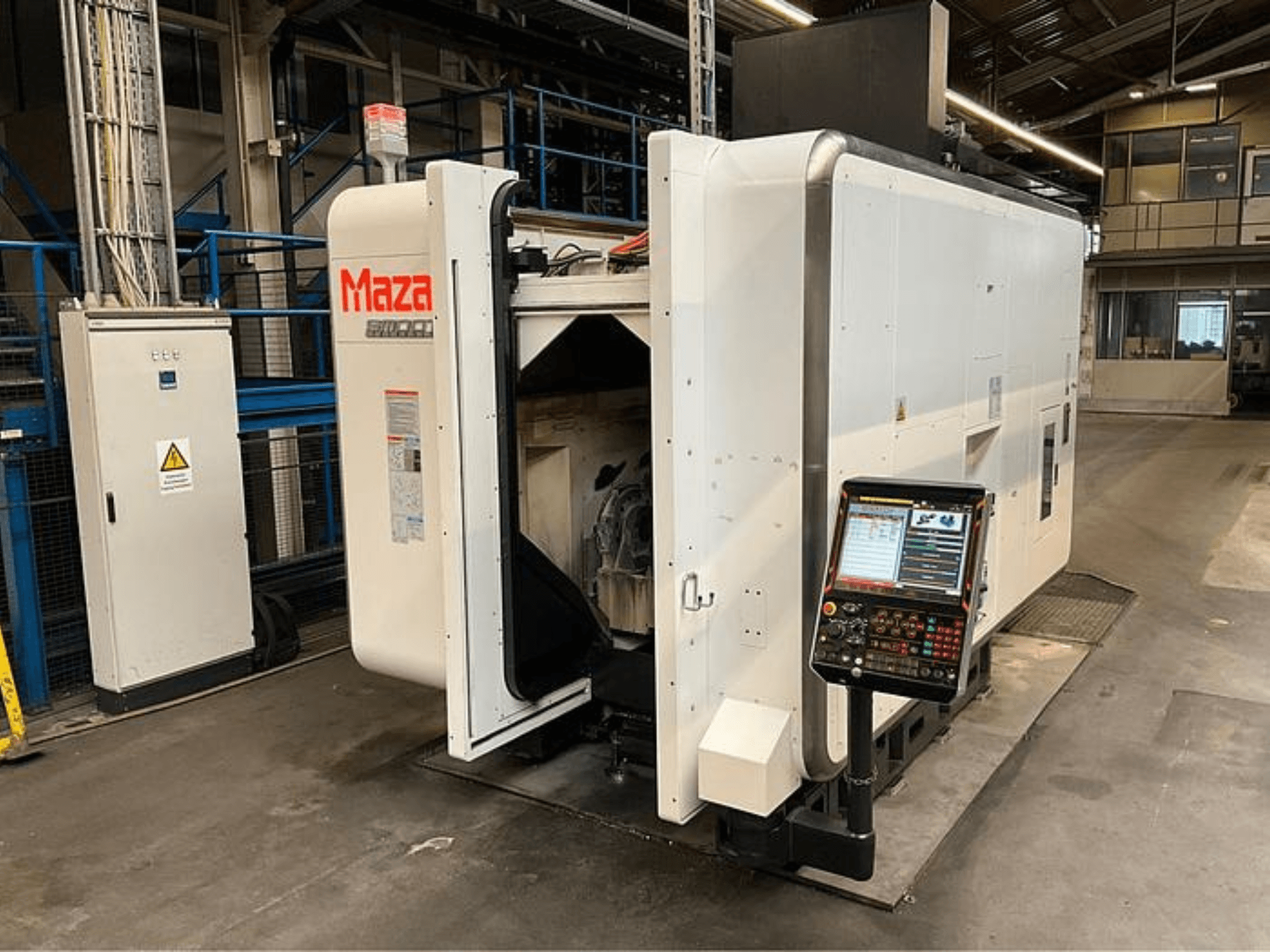 Máquina CNC Maza mostrada desde una vista frontal, con panel de control, diseño industrial y componentes de maquinaria visibles.