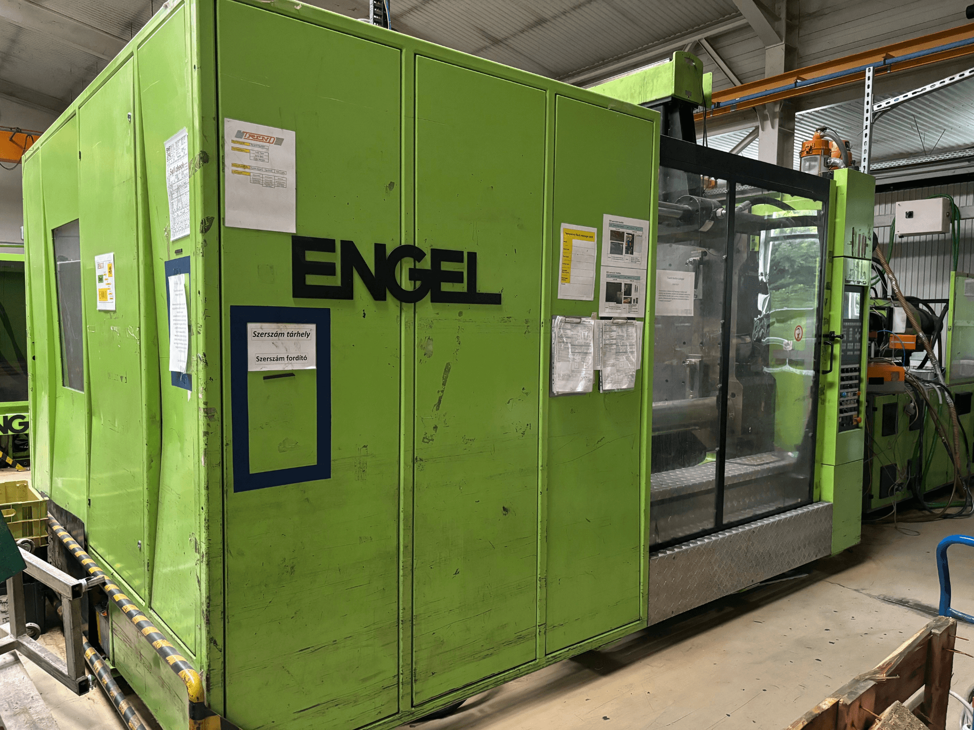 Máquina de moldeo por inyección hidráulica Engel DUO 5550/800, vista frontal, con exterior verde y panel de acceso transparente.