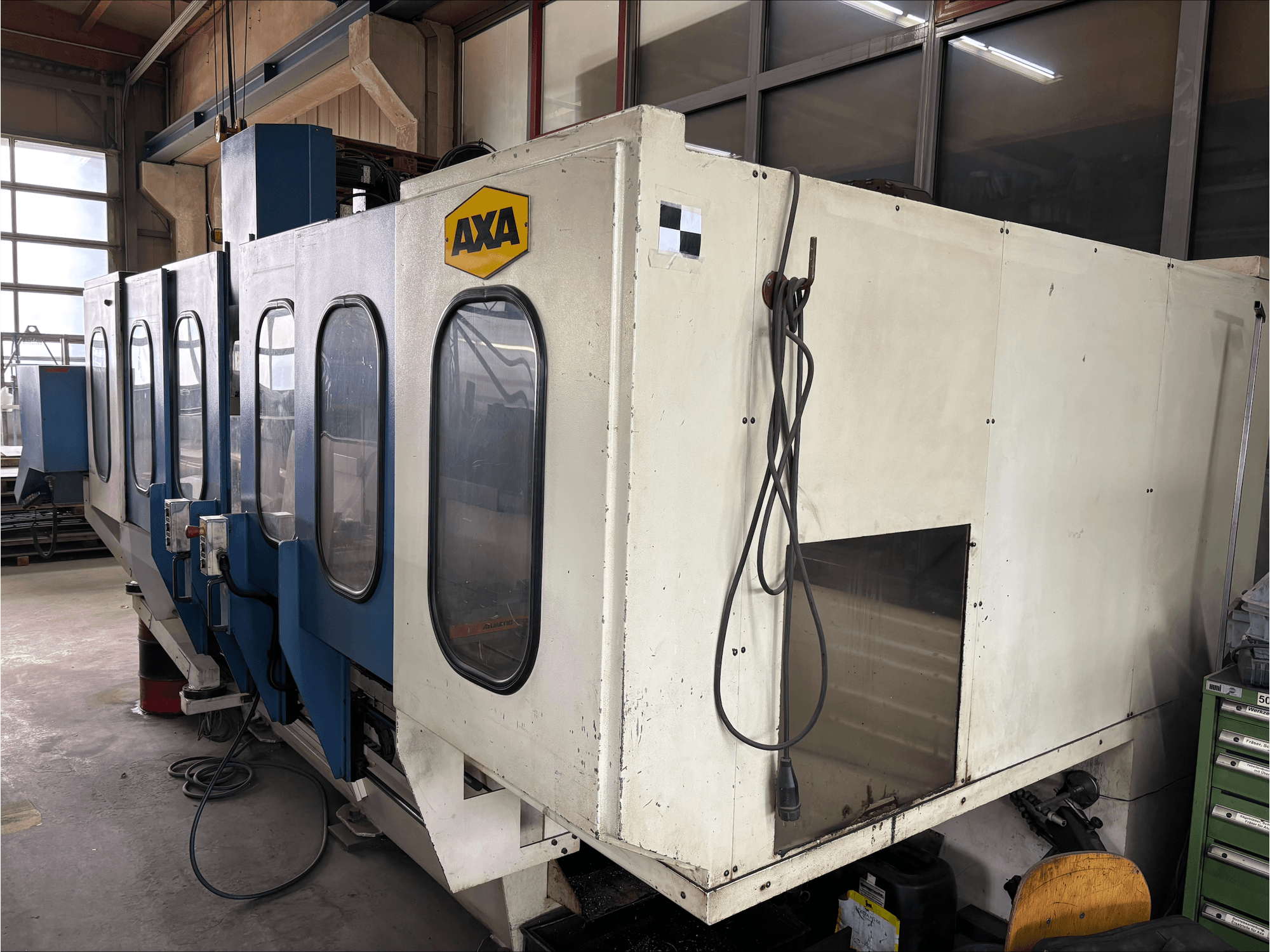 Centro de mecanizado vertical AXA VSC-1-M/C, vista frontal, con un gran armario blanco y panel de control azul.