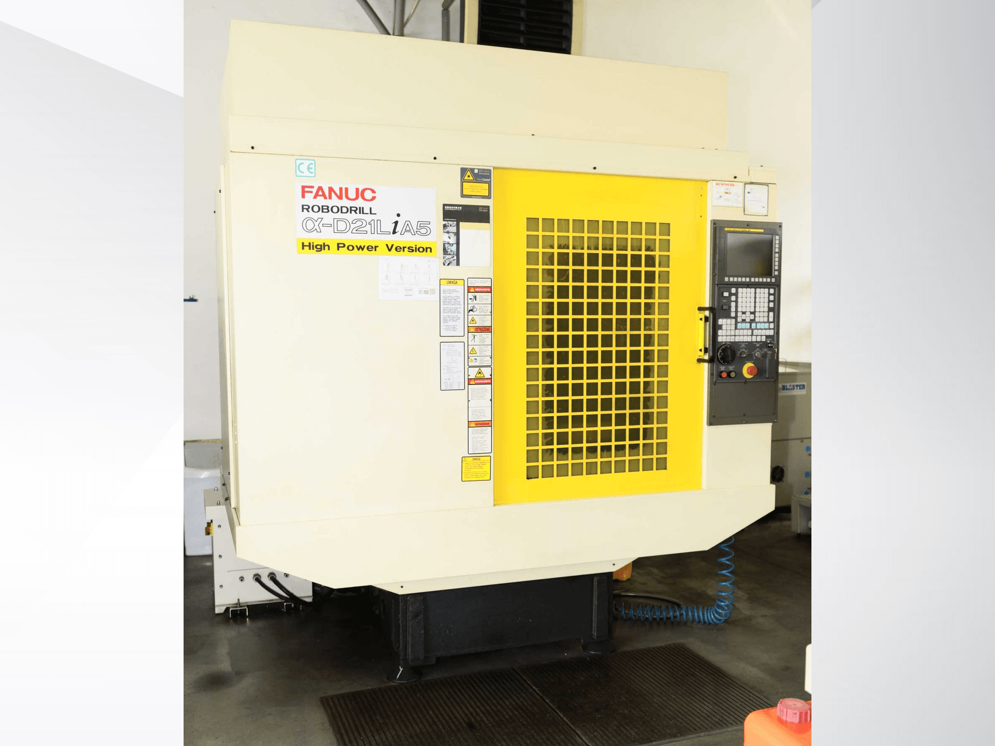 Centro de mecanizado vertical FANUC ROBODRILL α-D21LiA5, vista frontal con rejilla de seguridad amarilla y detalles del panel de control.