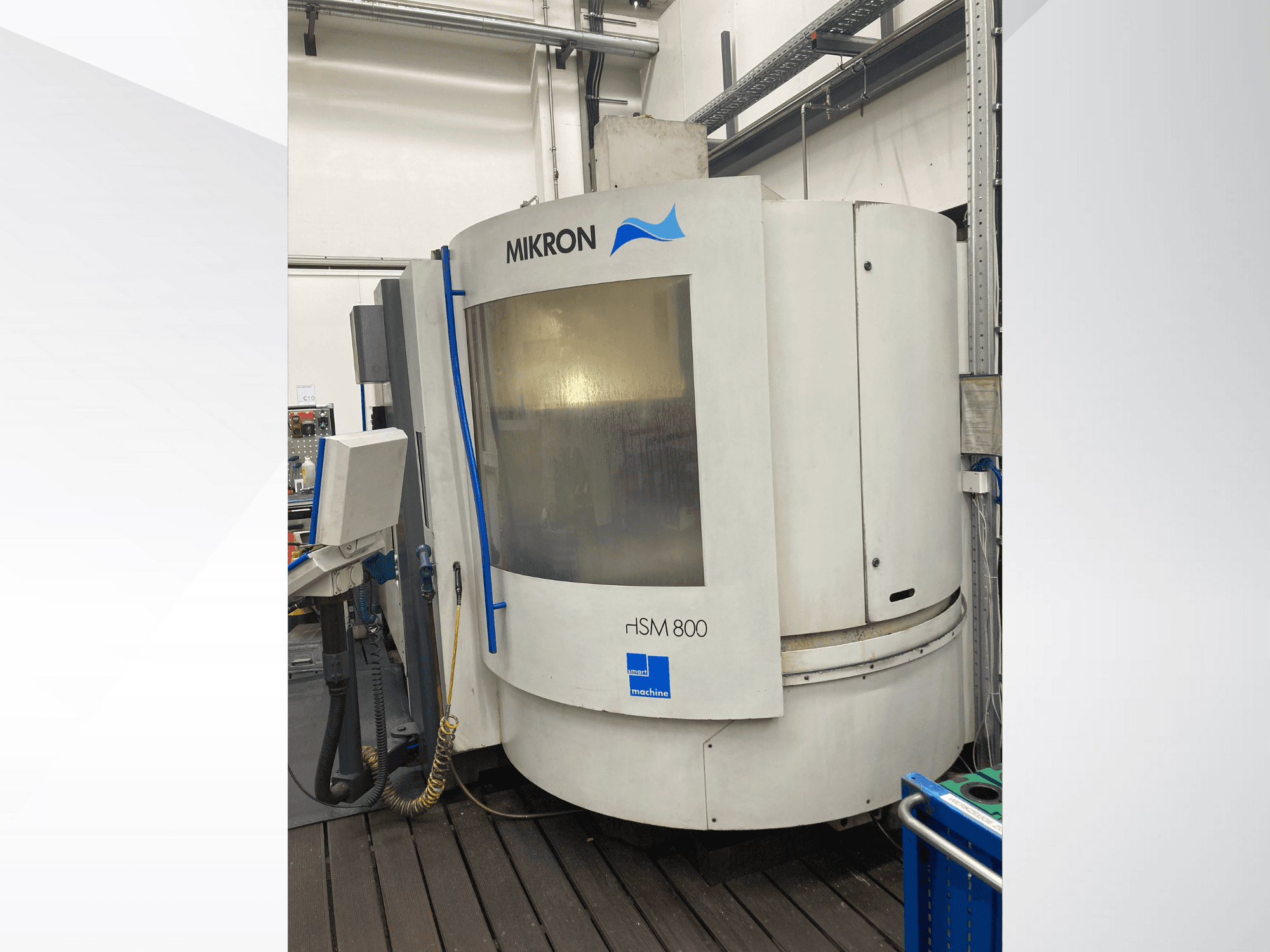 Máquina CNC Mikron rISM 800, vista frontal con panel de control, diseño cilíndrico y detalles en azul, situada en un entorno de taller.