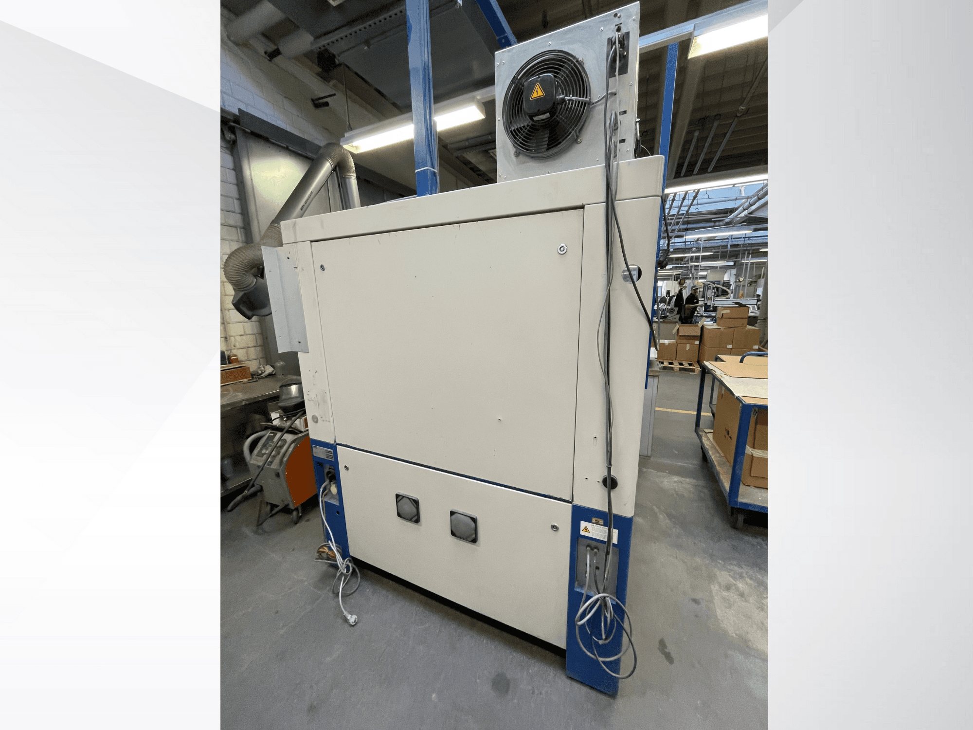 Secadora industrial con ventilador, vista lateral; dispone de ventilación y múltiples conexiones eléctricas. Marca/modelo no visible.