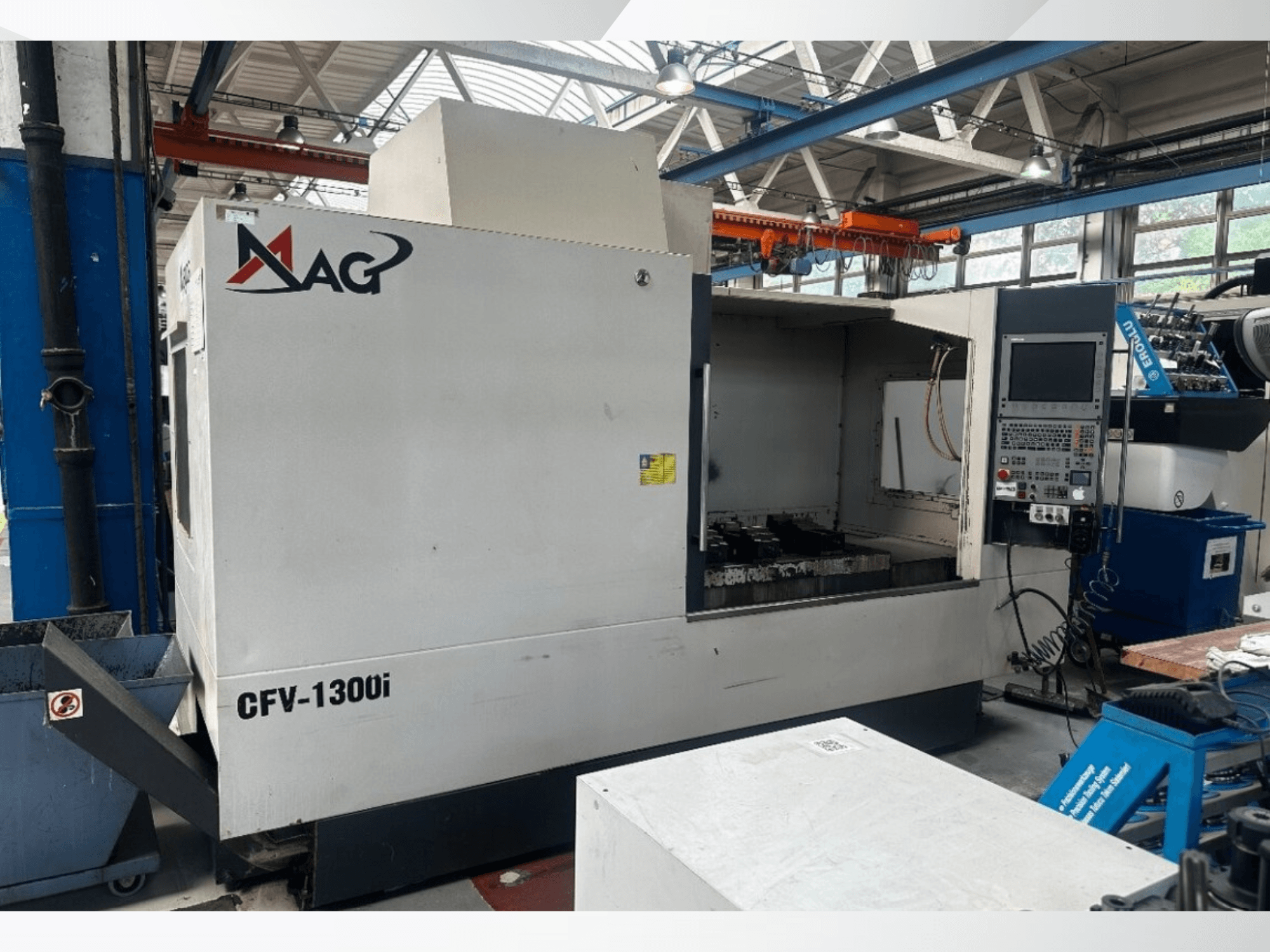 Centro de mecanizado vertical MAG CFV1300i de Cincinnati en un taller; vista frontal en la que se aprecian el panel de control y el interior de la máquina.