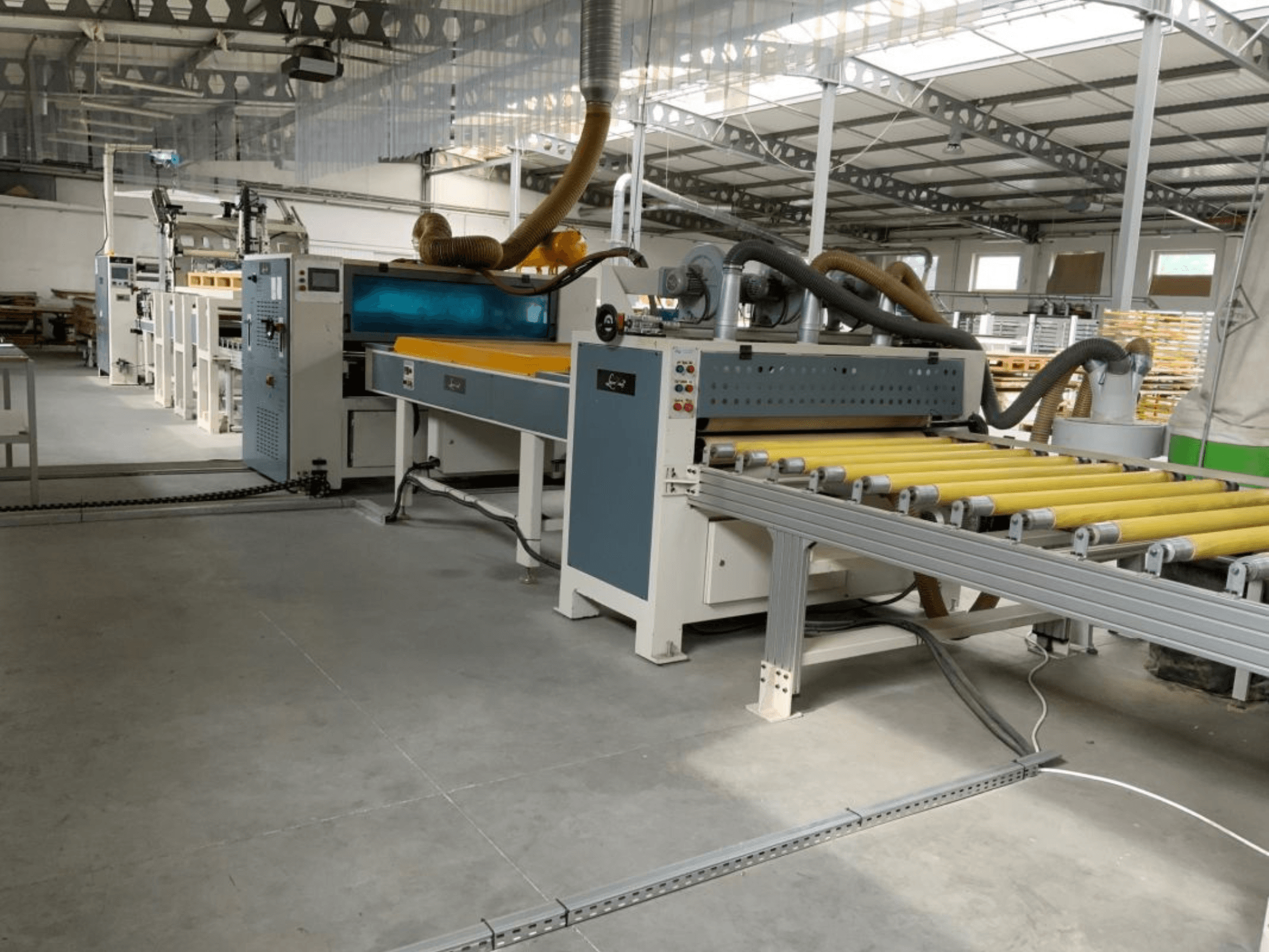 Prensa de laminación MASTER PUR-1400 en un entorno industrial, vista frontal, en la que se aprecian los rodillos y los controles de funcionamiento.