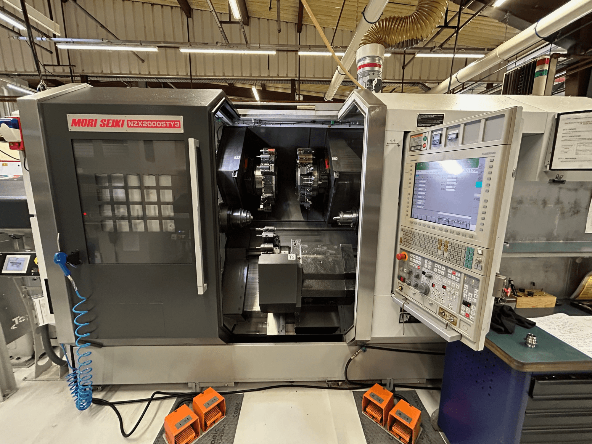 Torno multihusillo MORI SEIKI NZ2000 ST3Y3, vista frontal en la que se aprecian el panel de control y la zona de mecanizado.
