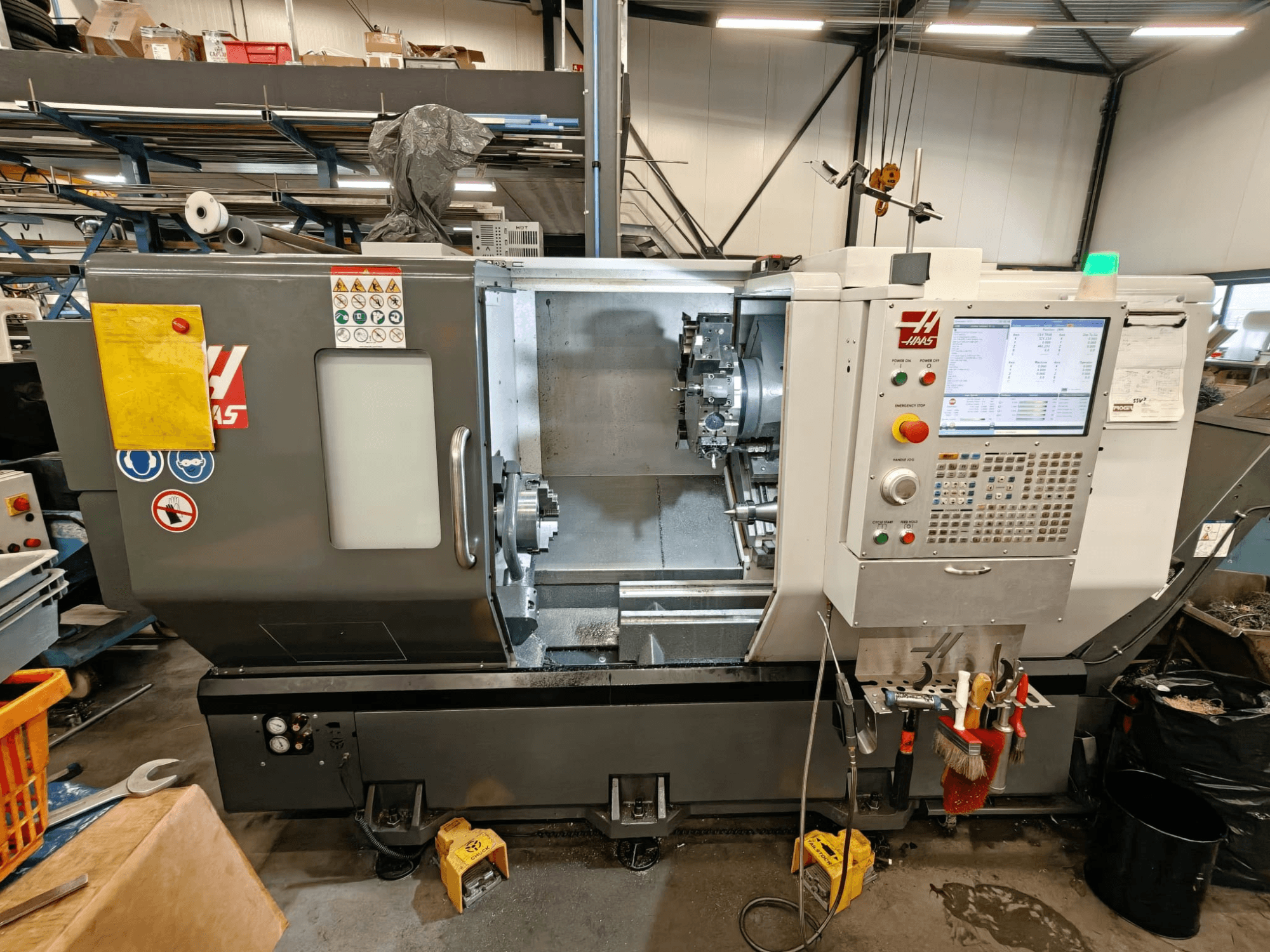Tornos horizontales HAAS ST-25Y, vista frontal, mostrando el panel de control, el almacenamiento de herramientas y la configuración operativa en el taller.