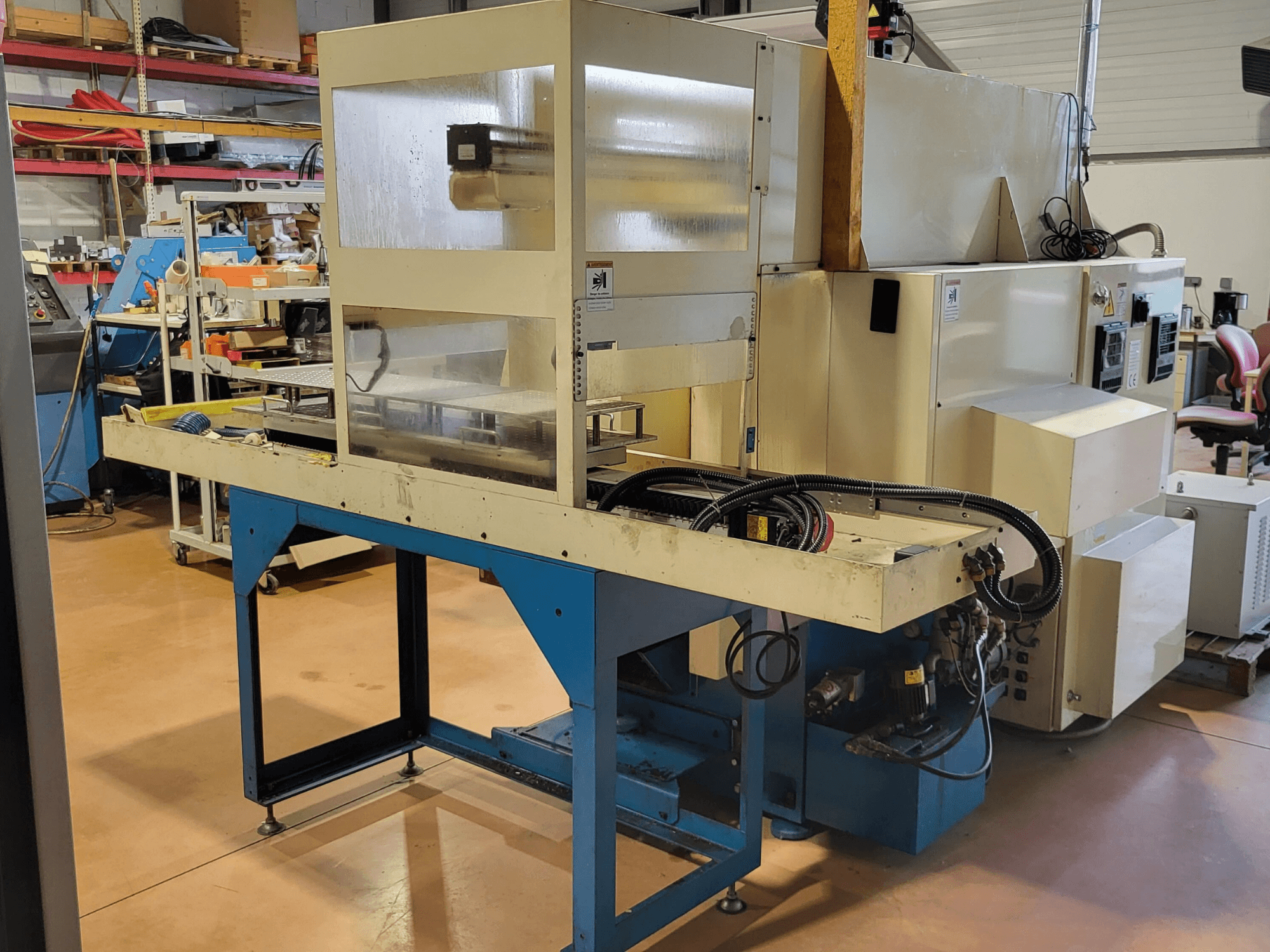 Máquina de torneado horizontal Kitamura KNC 150 NSA, vista lateral que muestra el panel de control y la configuración operativa en el taller.