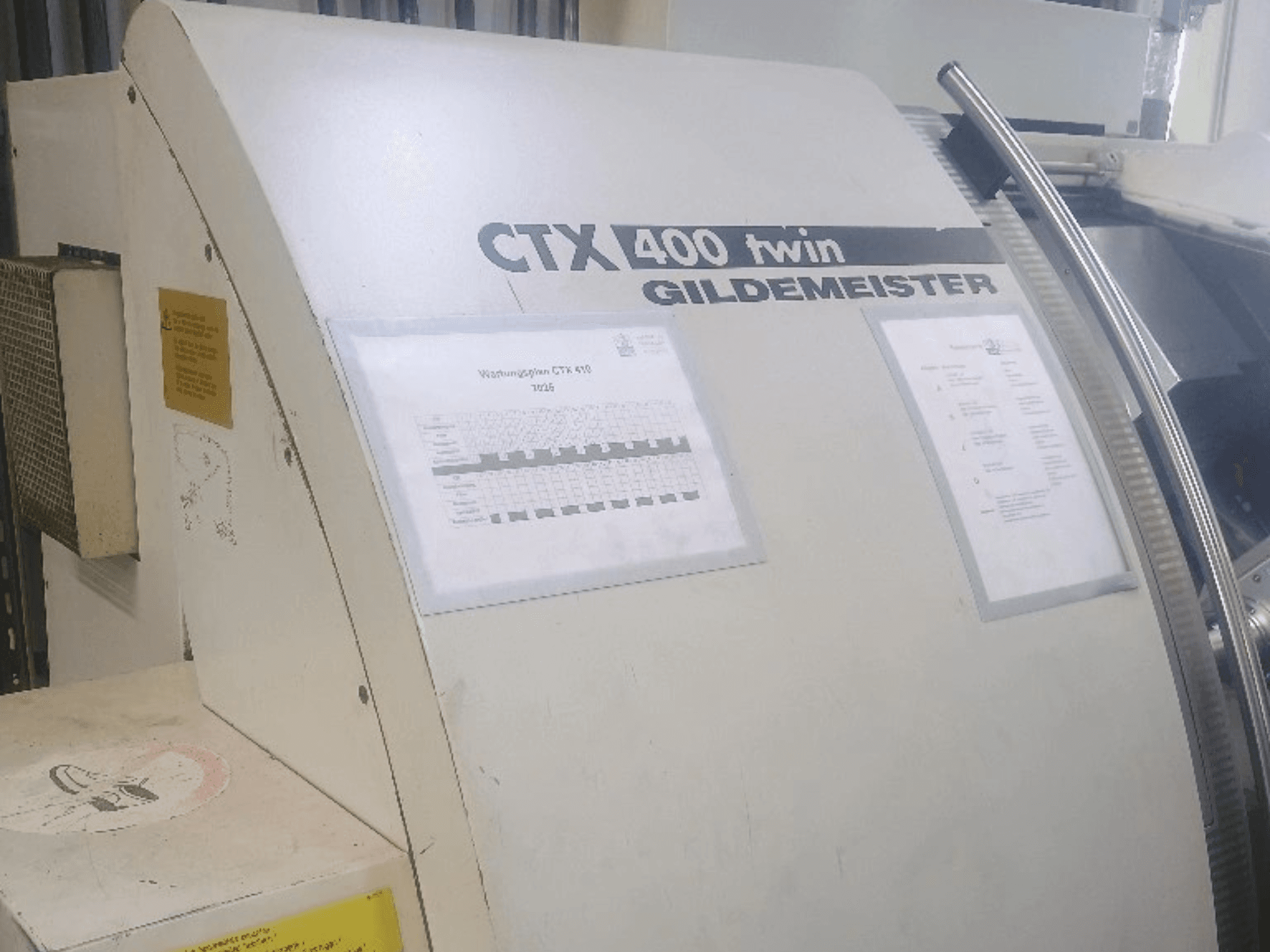 Torno horizontal doble Gildemeister CTX 400, vista frontal, en la que se aprecian los paneles de control y la documentación técnica.