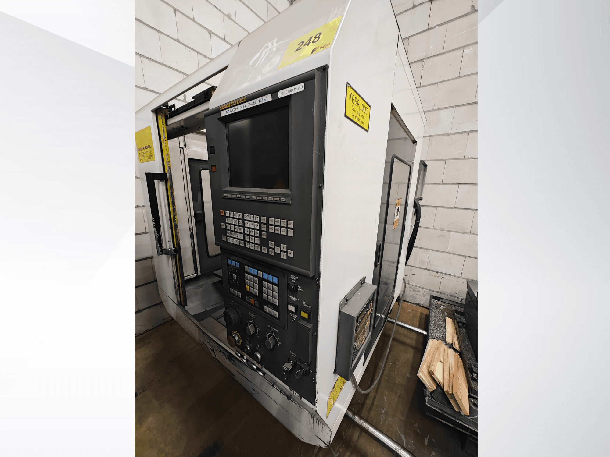 Máquina CNC modelo Nr 248, vista frontal, con un panel de control con botones y pantalla, con piezas de madera en un estante cercano.