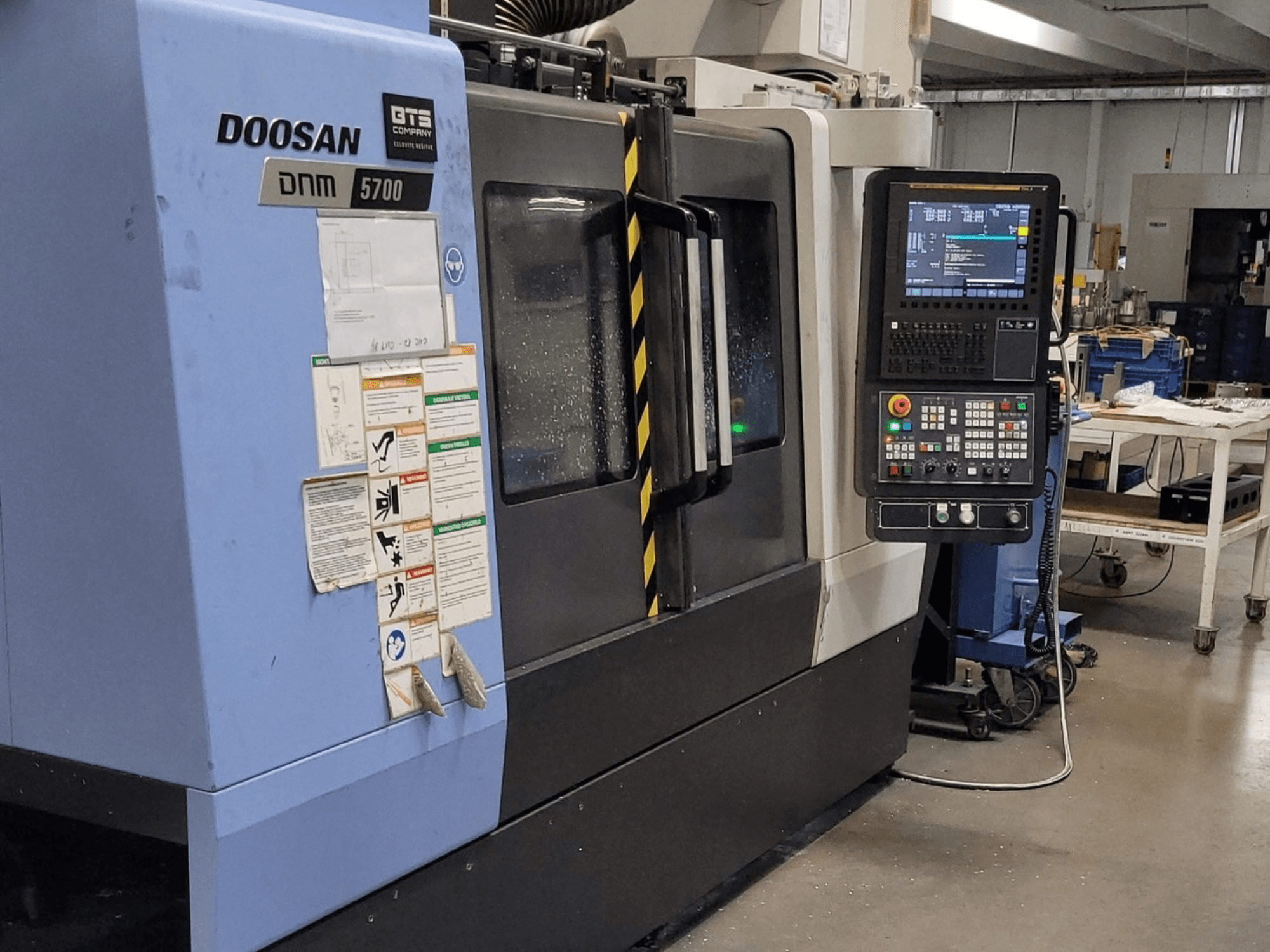 Centro de mecanizado vertical DOOSAN DNM 5700, vista frontal, en la que se aprecian el panel de control y los mandos de funcionamiento.