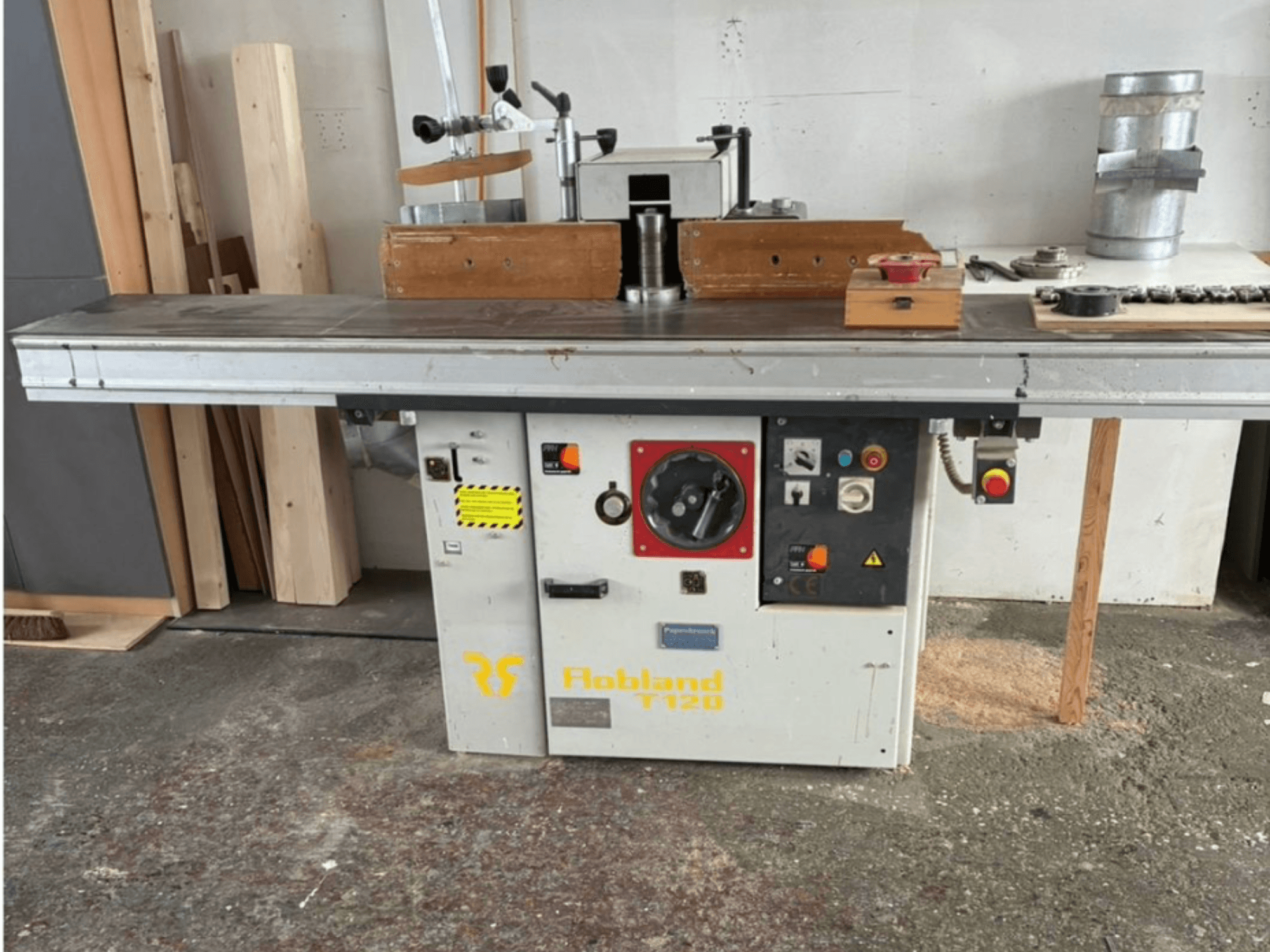 Cepilladora de mesa Hobbland T120, vista frontal, presenta una superficie plateada, panel de control con botones y etiquetas de seguridad.